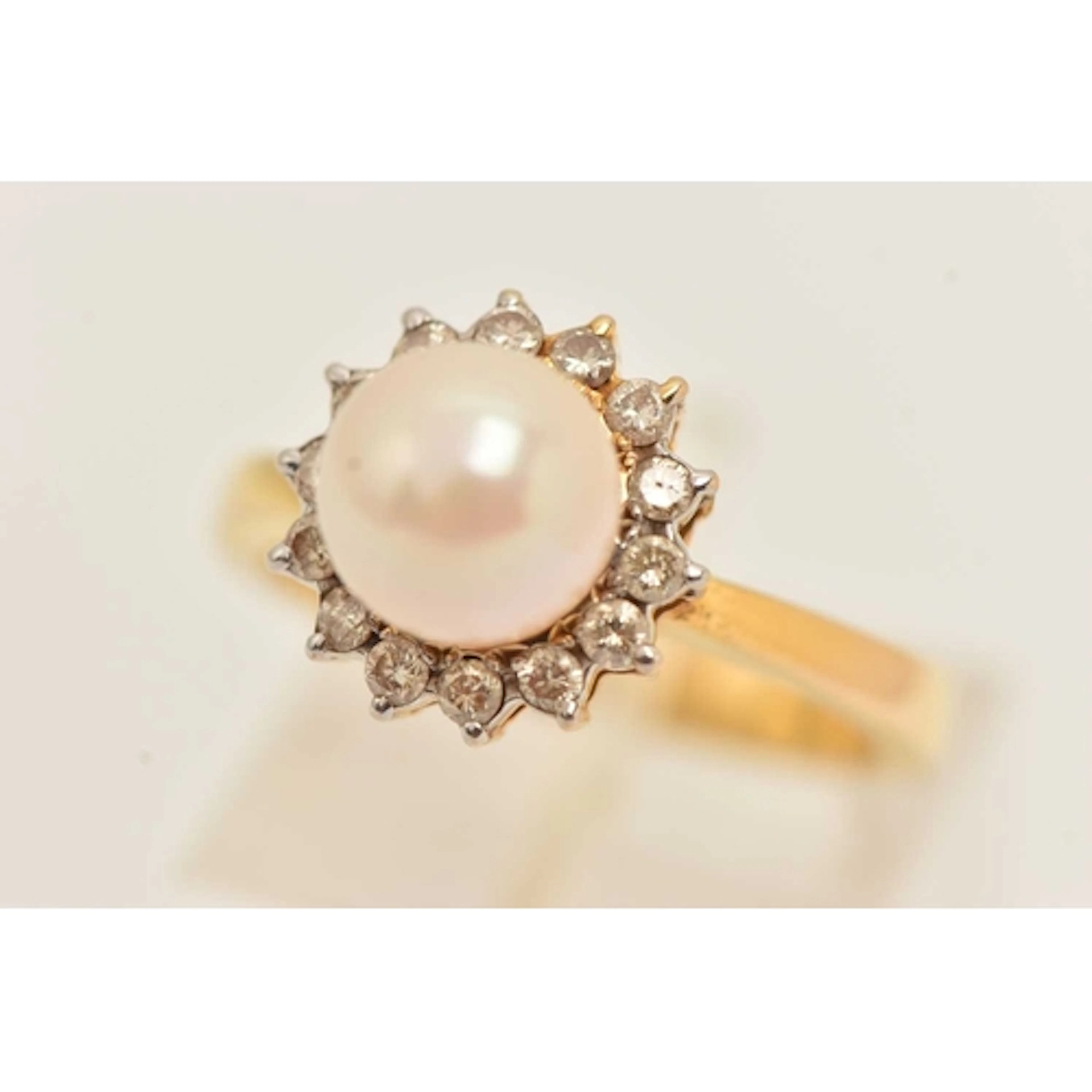 A CULTURED PEARL AND DIAMOND RING, a yellow metal ring set w...