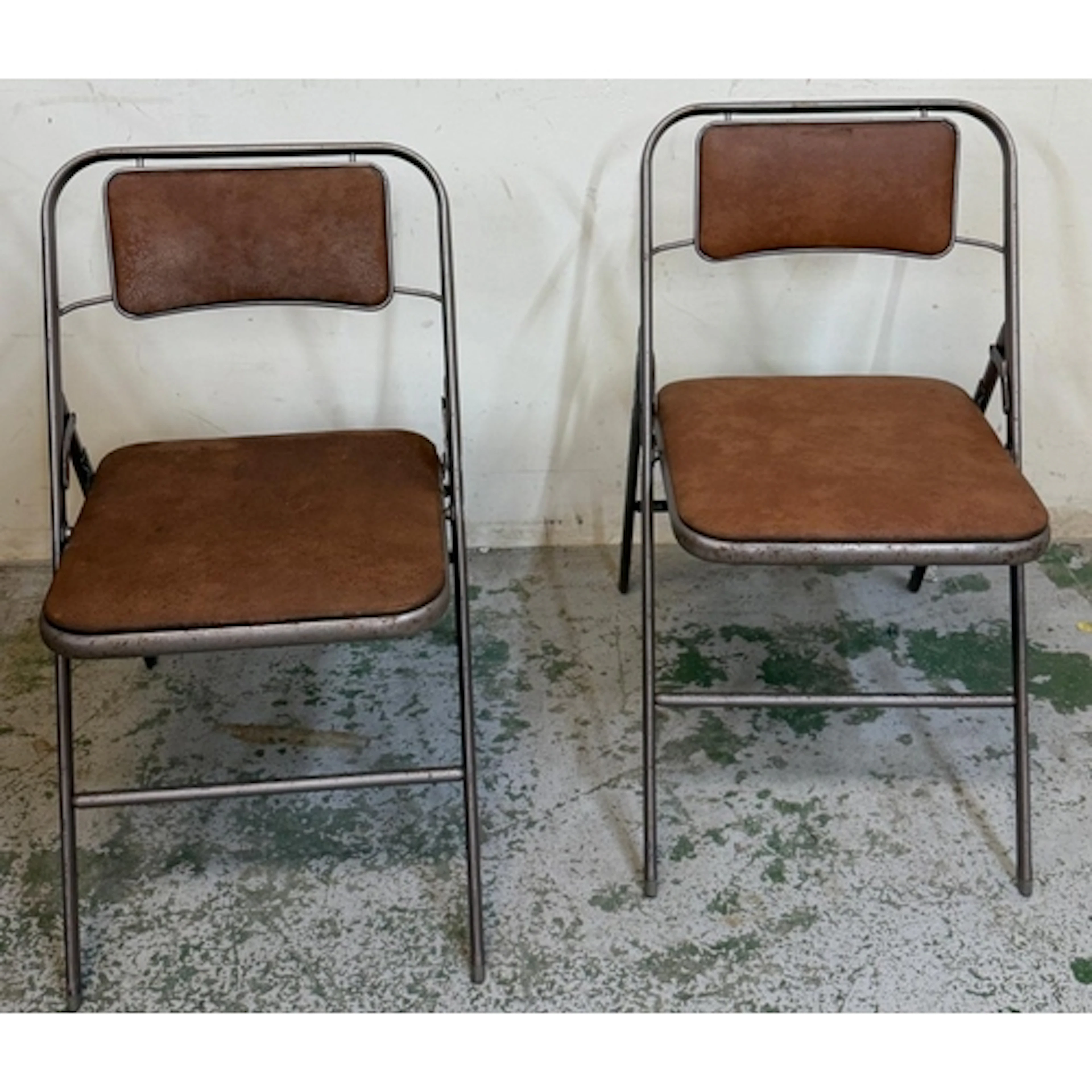 A pair of industrial style folding chairs by Samsonite....