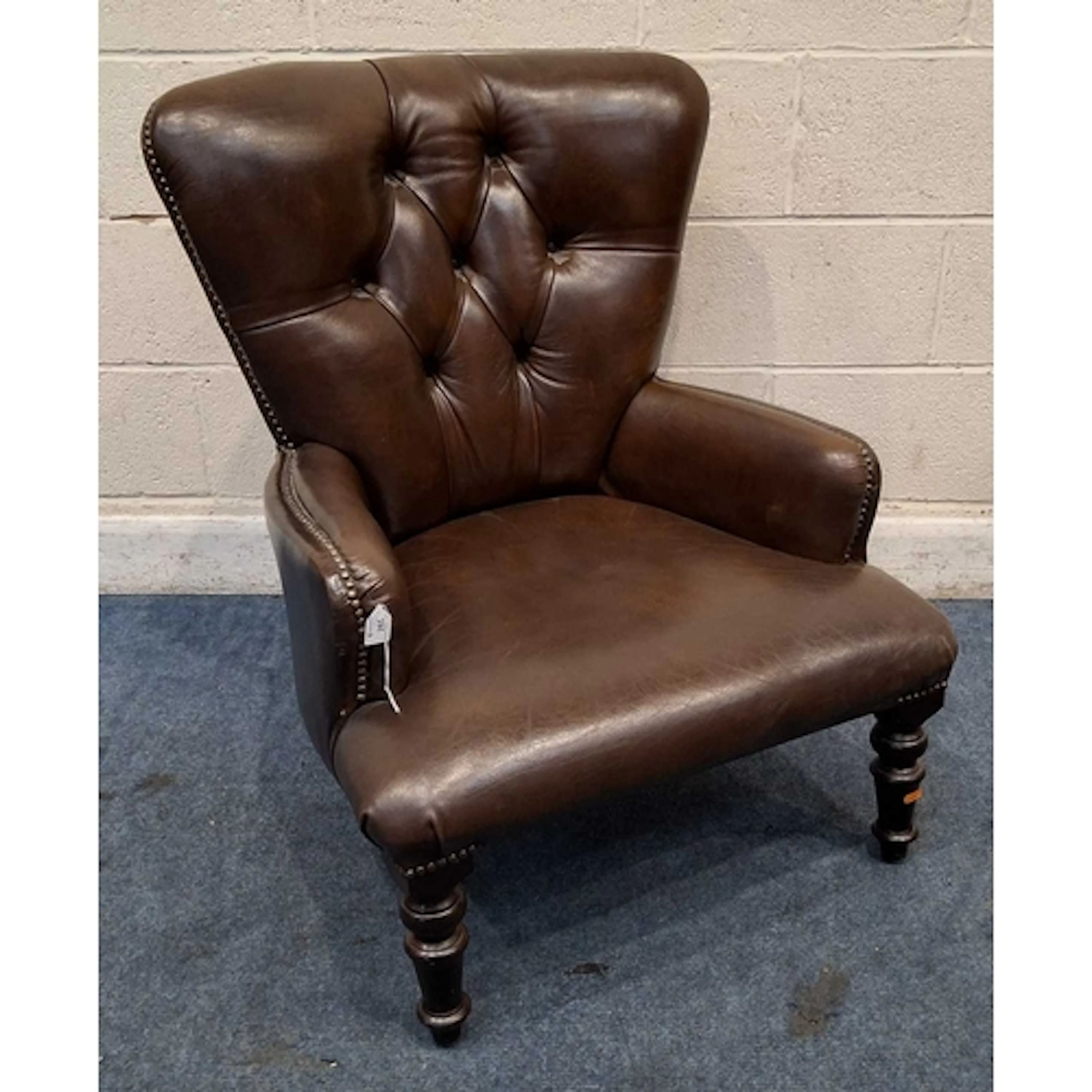 A BROWN LEATHER BUTTON BACK ARMCHAIR (width 70cm x depth 78...