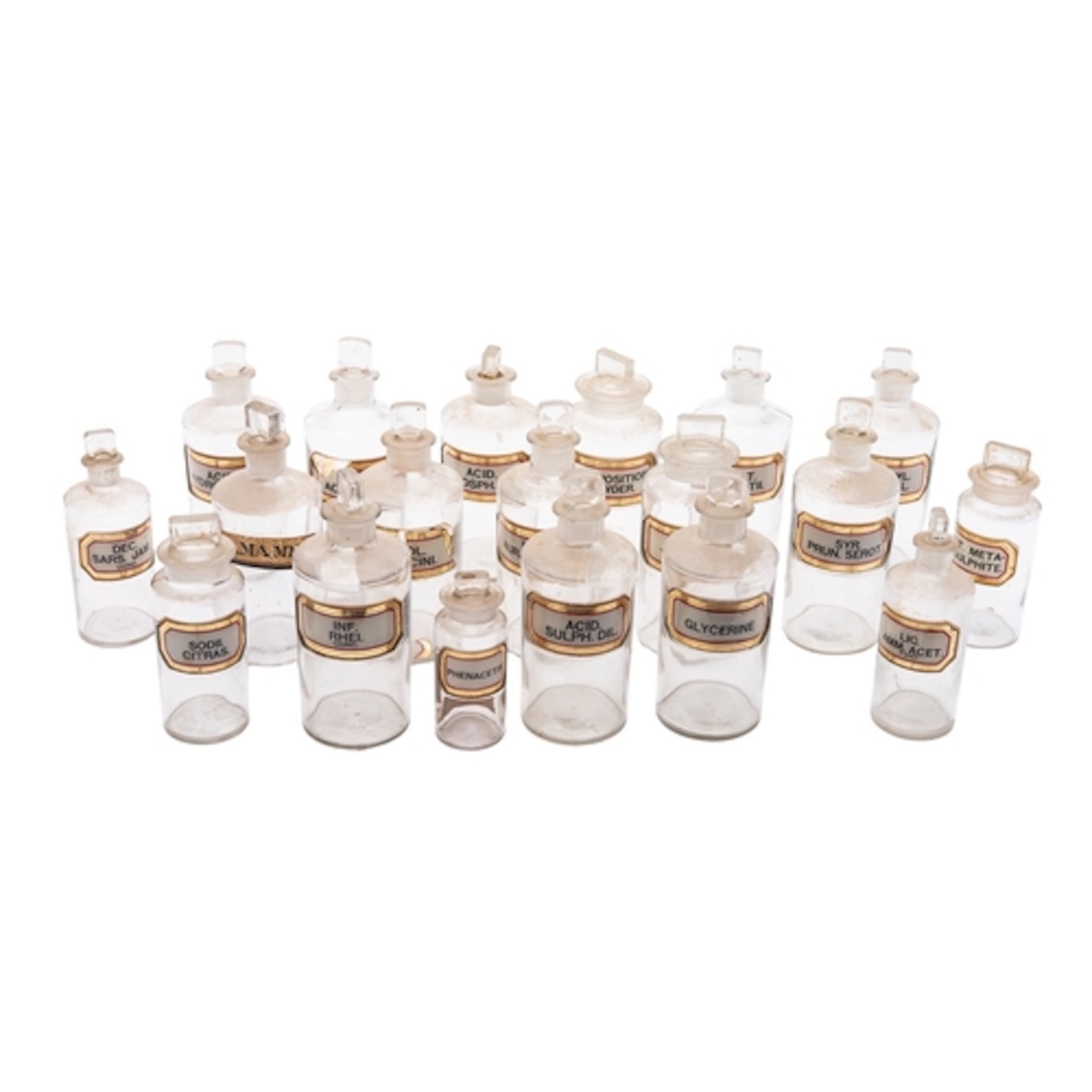 A mixed group of clear glass apothecary bottles and stoppers...
