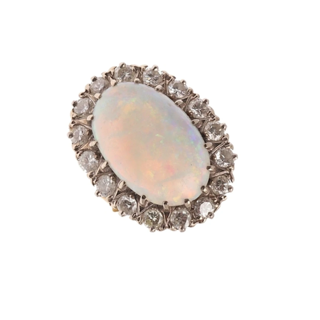 AN OPAL AND DIAMOND CLUSTER RING. the oval-shaped solid whit...