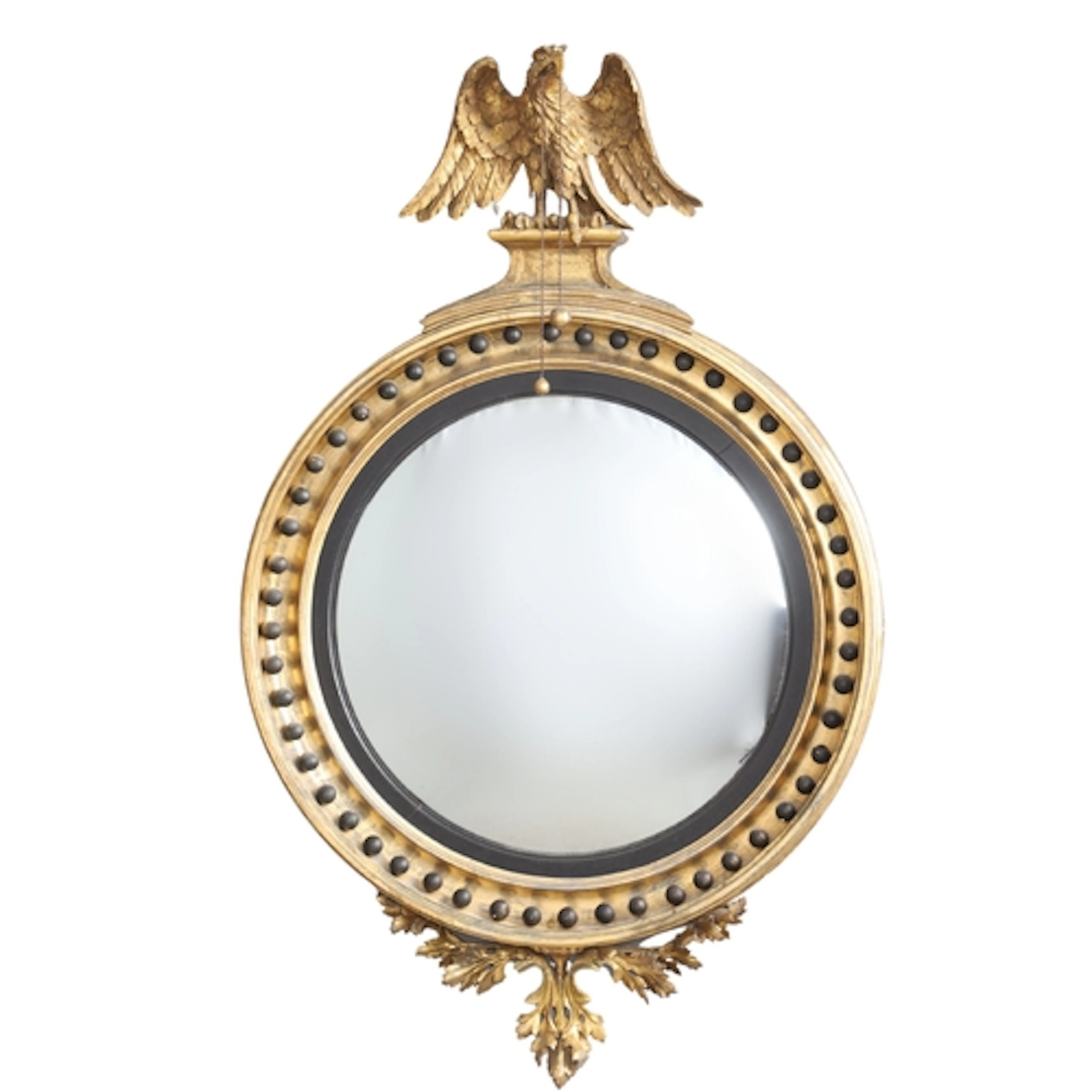 A REGENCY GILTWOOD AND EBONISED CONVEX MIRROR. the carved ea...