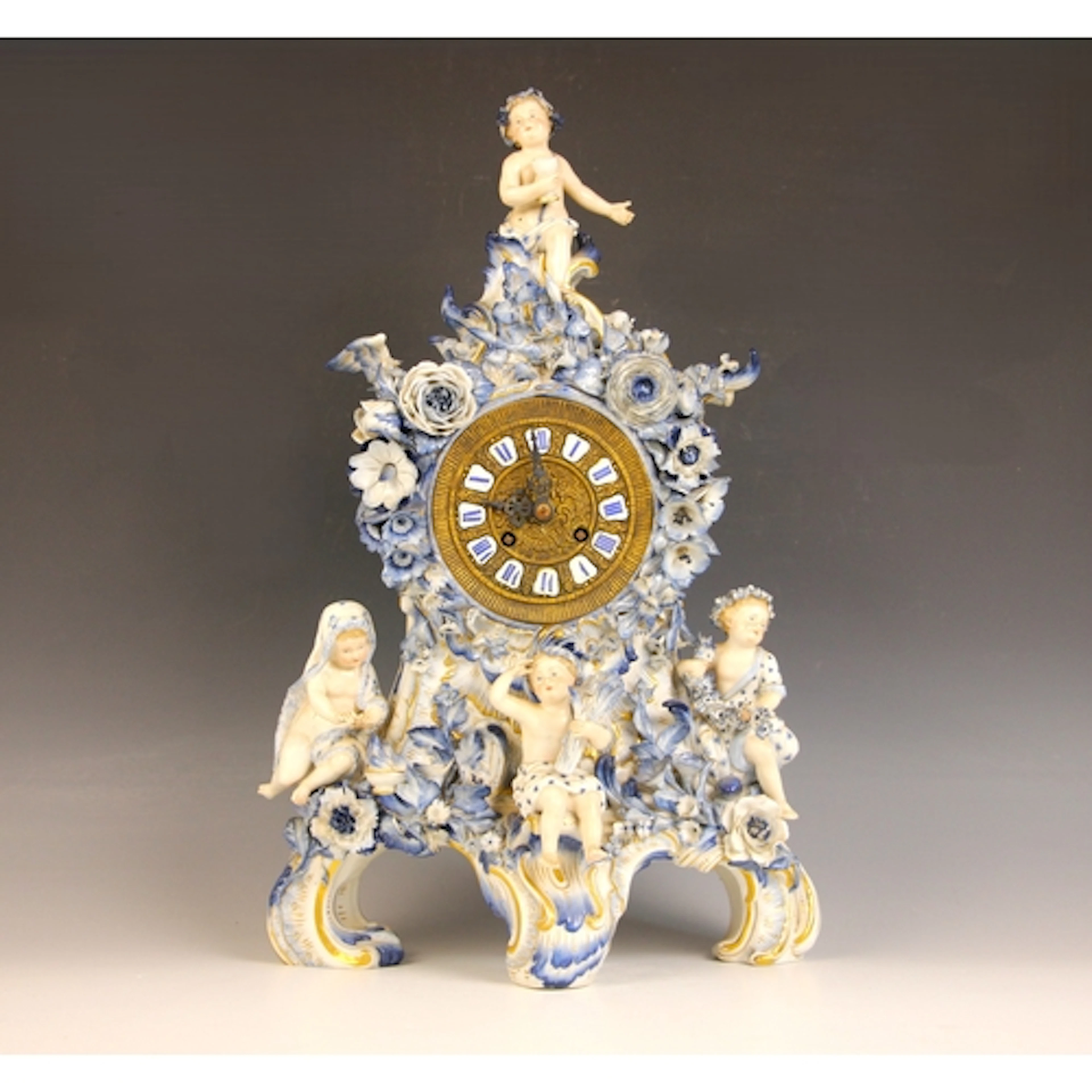 A Meissen blue and white porcelain figural mantel clock, lat...