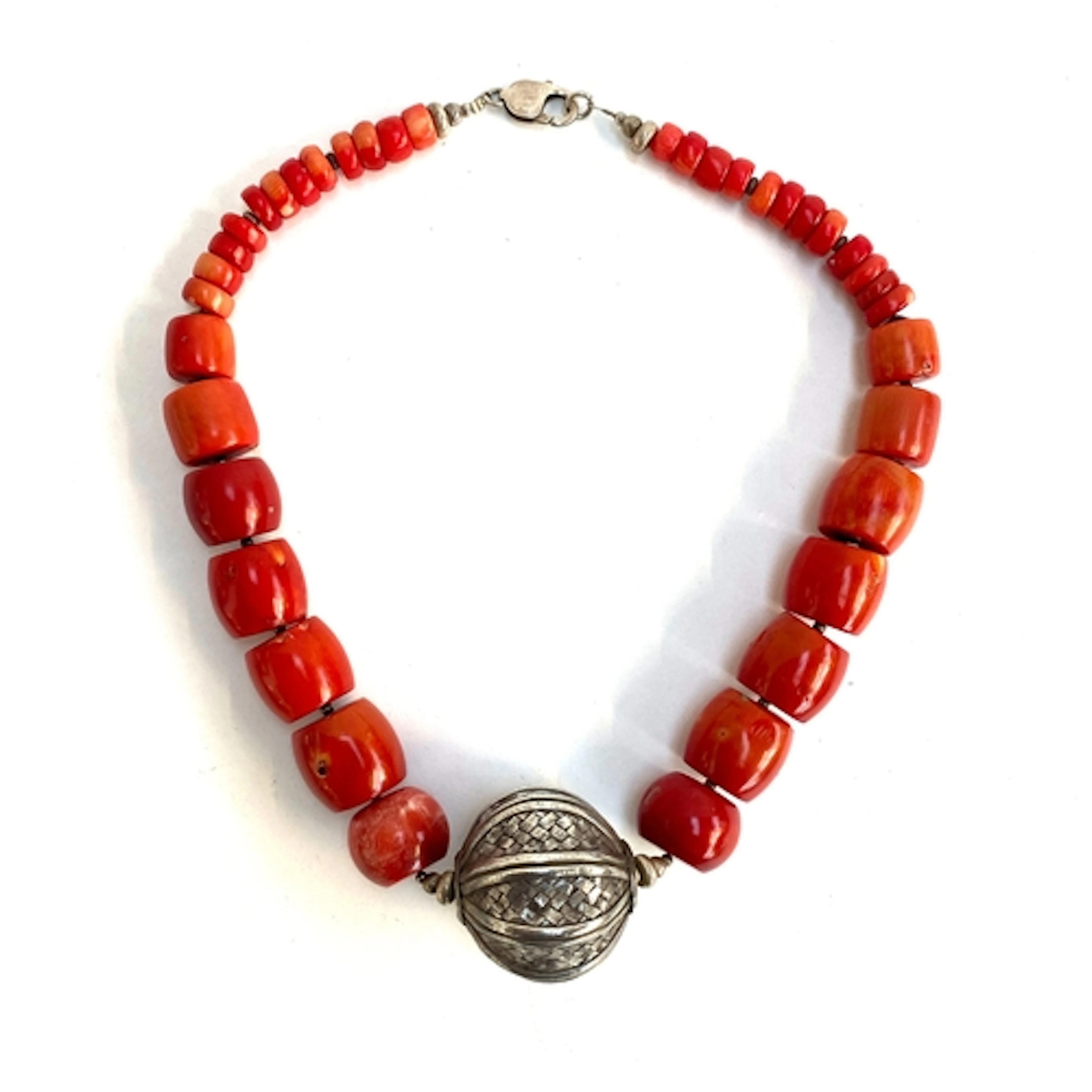 A heavy coral bead necklace with a large central woven silve...