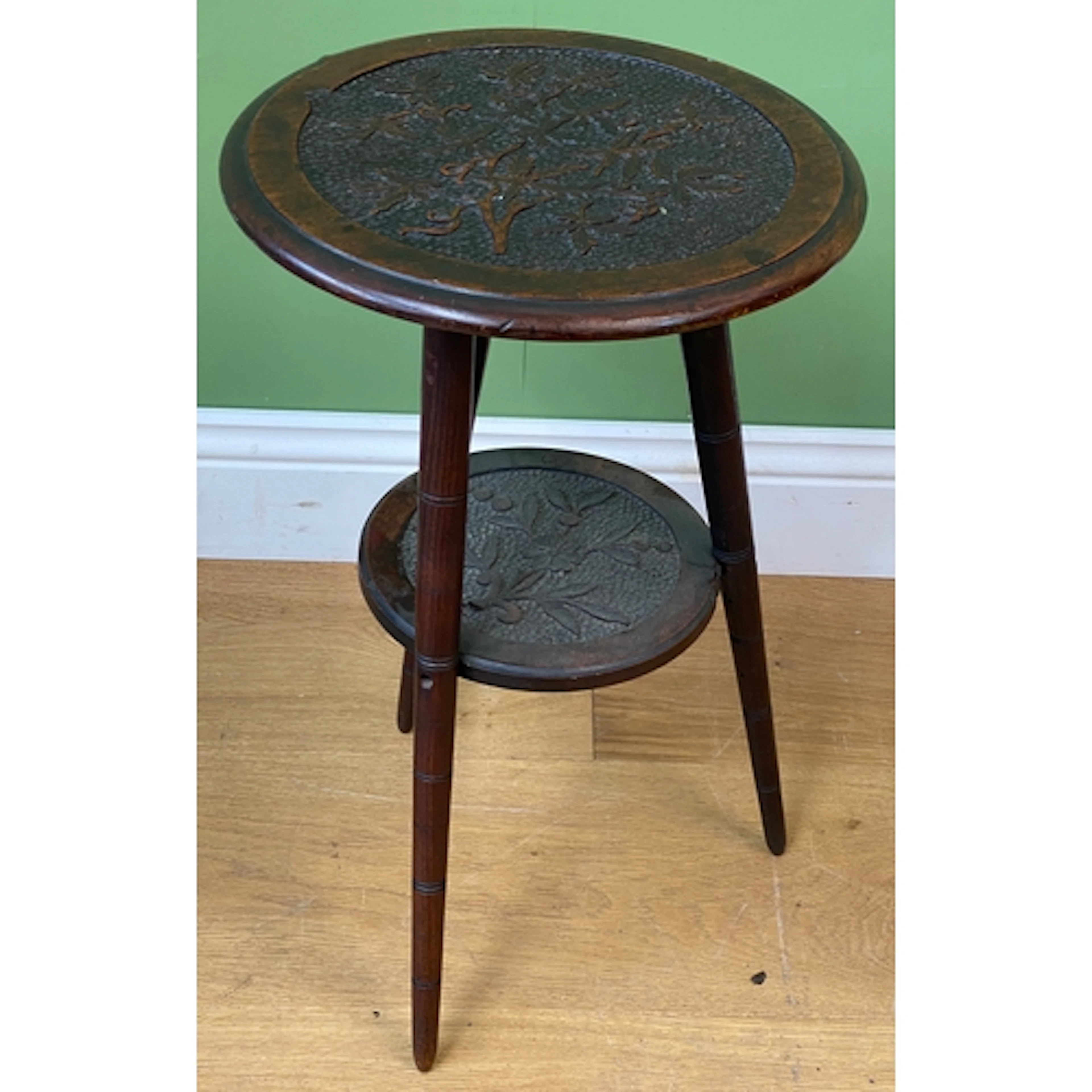 A circular occasional table with carved top and undershelf, ...