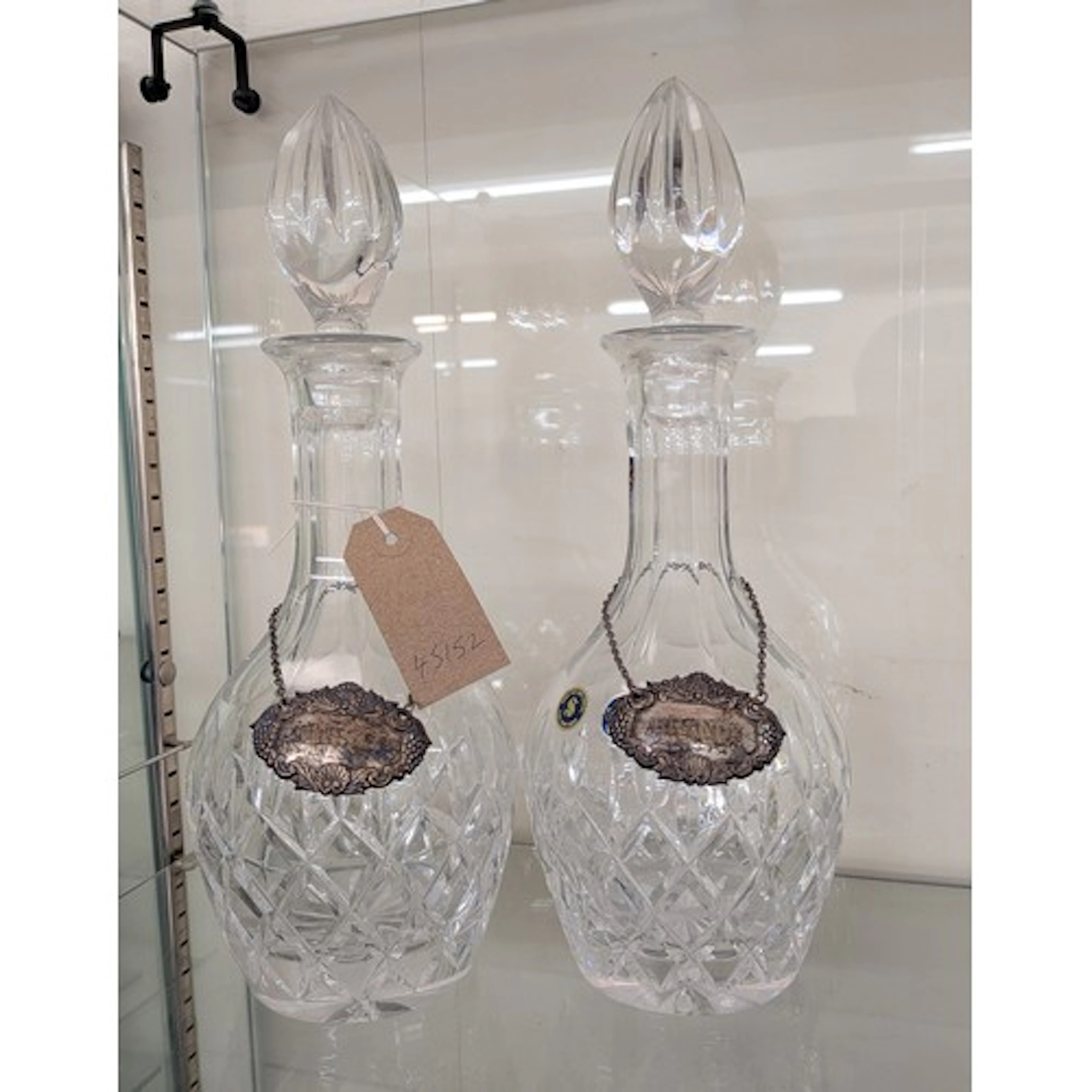 Pair of cut glass decanters with silver decanter labels