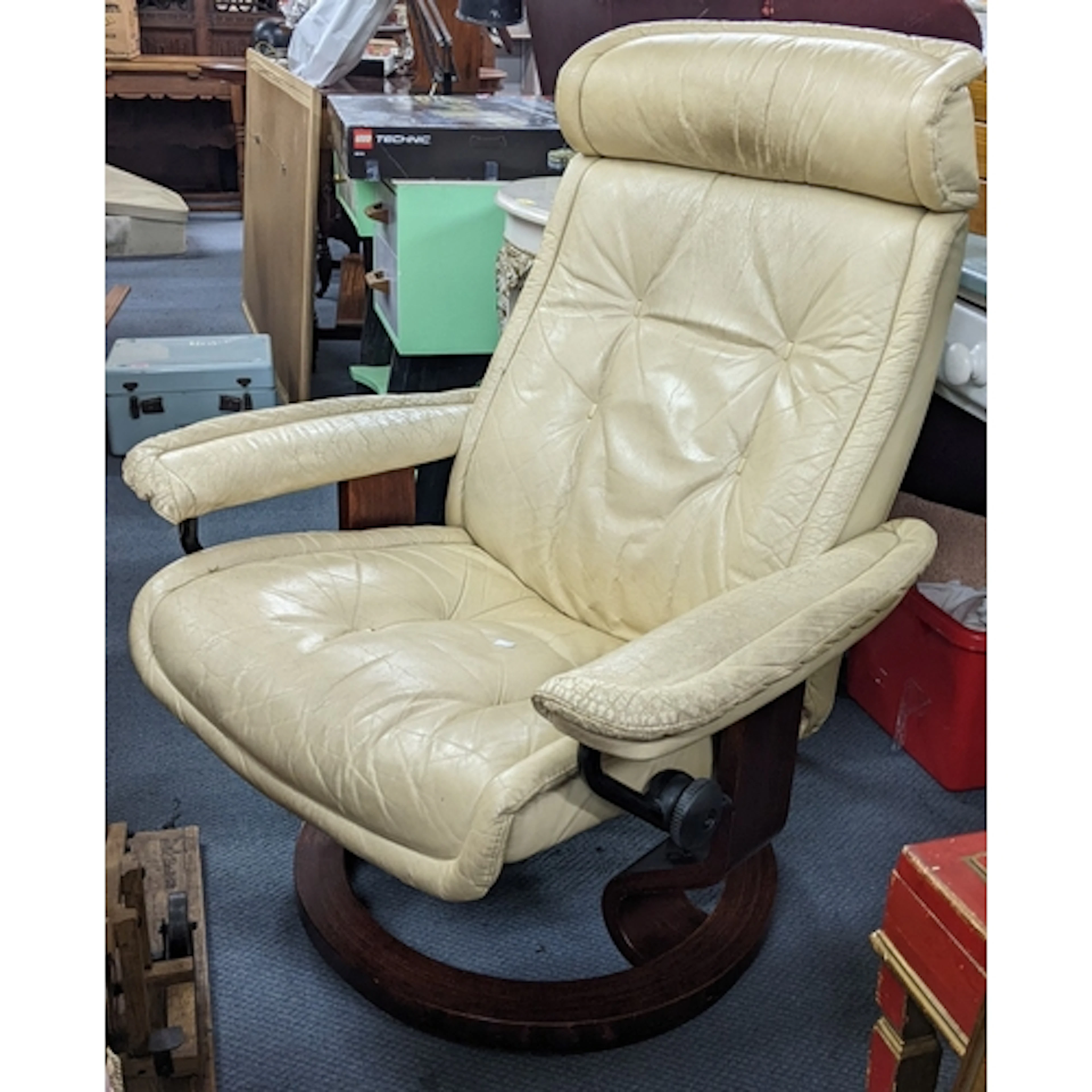 A vintage cream leather upholstered swivel reclining chair, ...