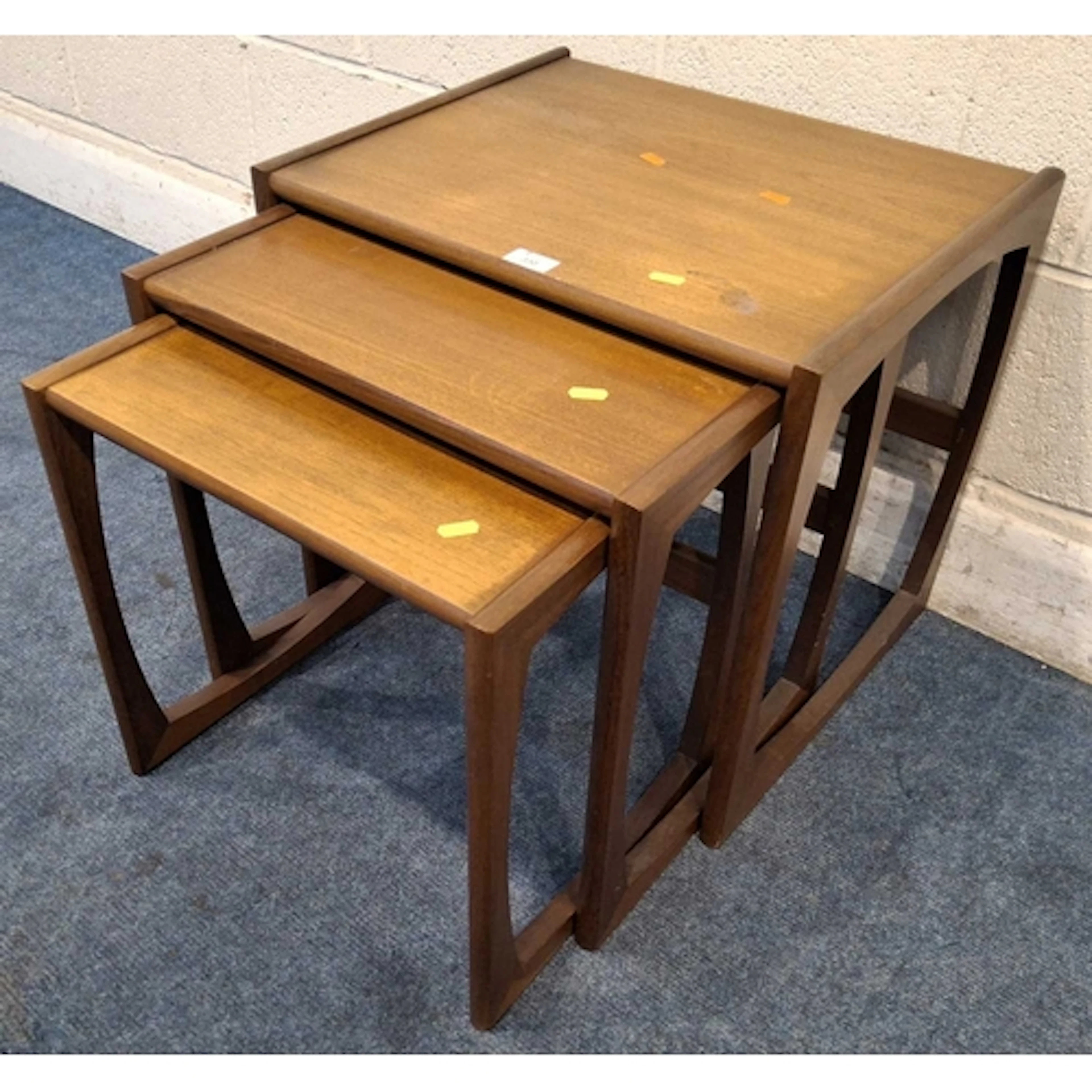 A MID-CENTURY TEAK G PLAN QUADRILLE NEST OF THREE TABLES (l...