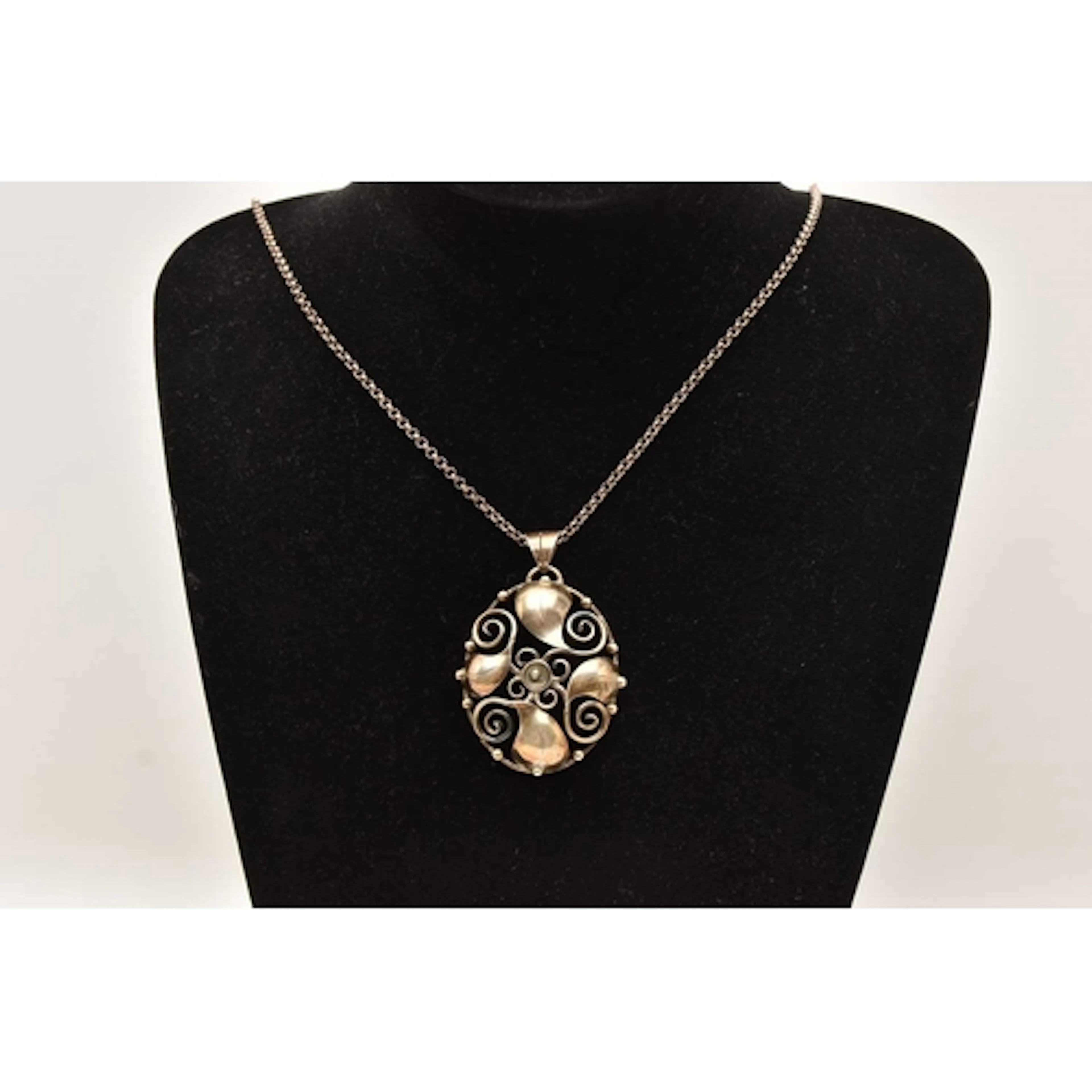 A LARGE WHITE METAL PENDANT NECKLACE, open work foliate patt...
