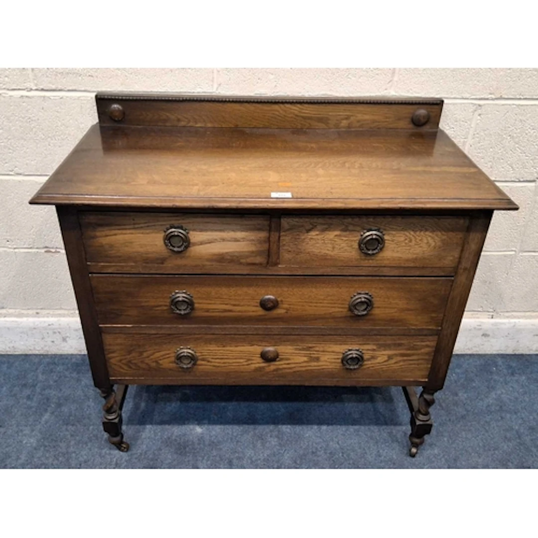 AN EARLY 20TH CENTURY OAK CHEST OF TWO SHORT OVER TWO LONG D...