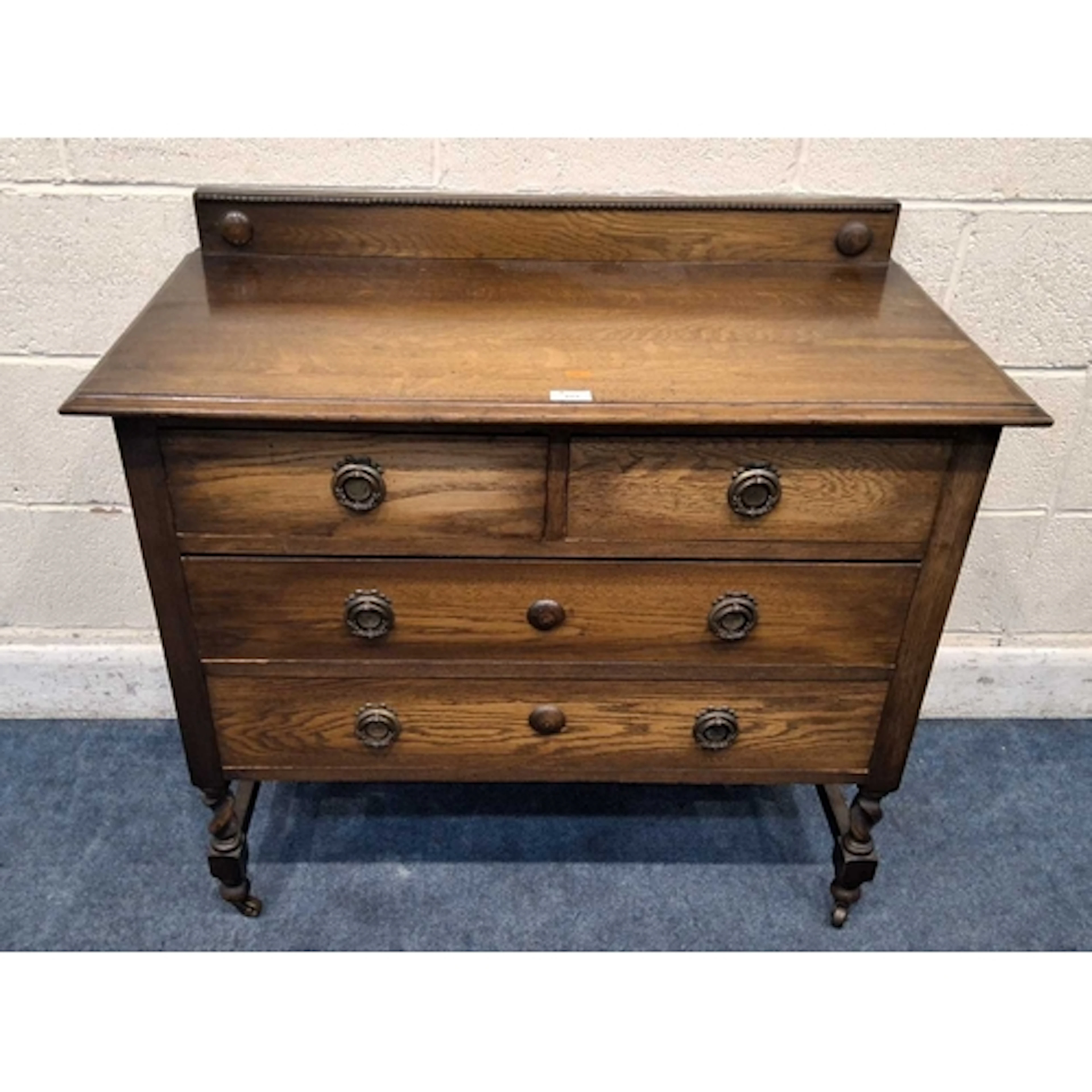 AN EARLY 20TH CENTURY OAK CHEST OF TWO SHORT OVER TWO LONG D...