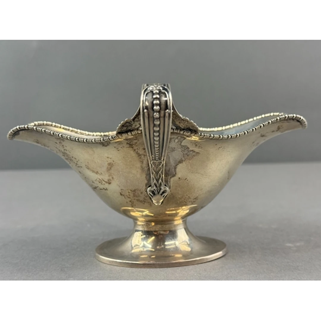 Silver: an Edward VII double lipped pedestal sauce boat by B...