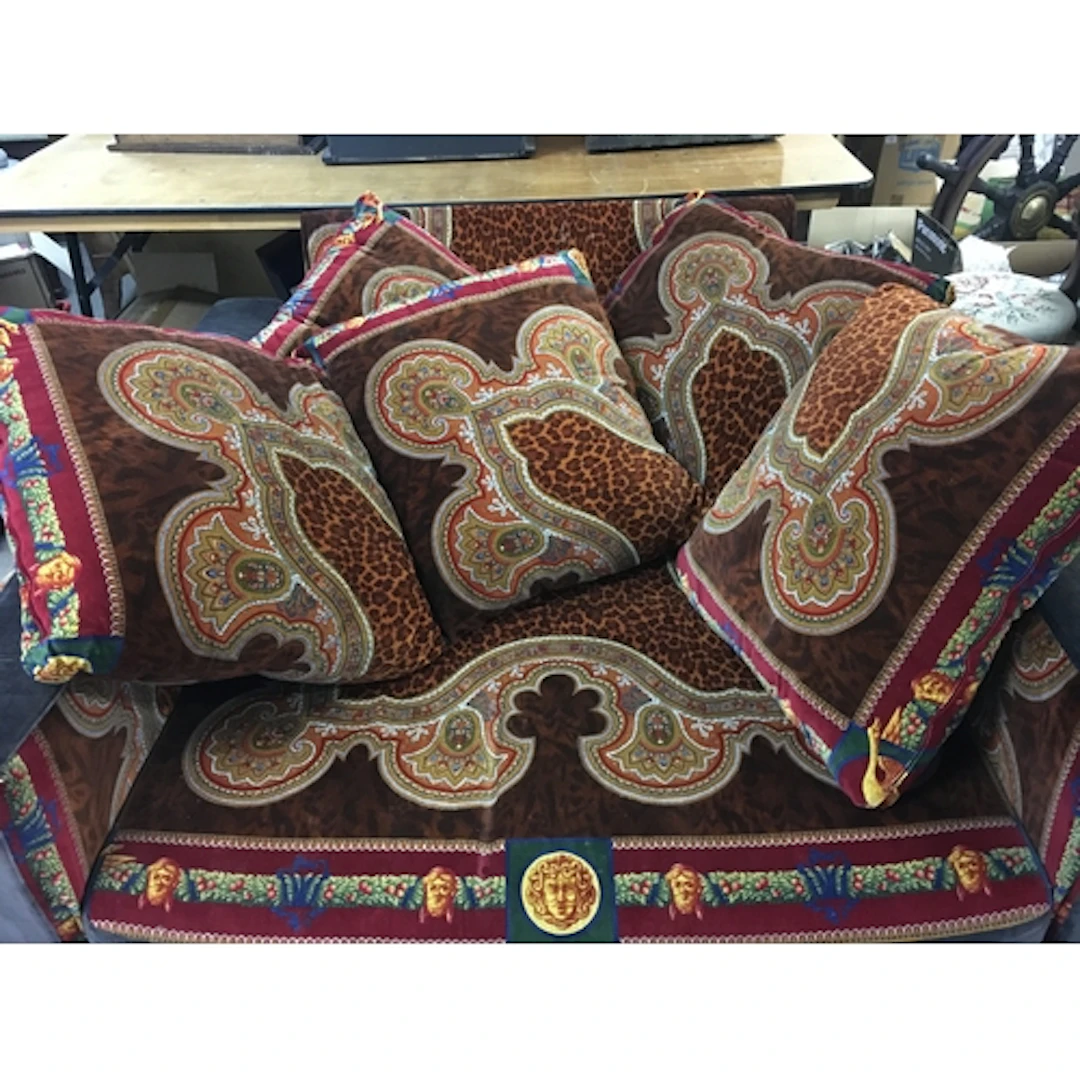 A three piece Versace suite including two sofas, a large cha...