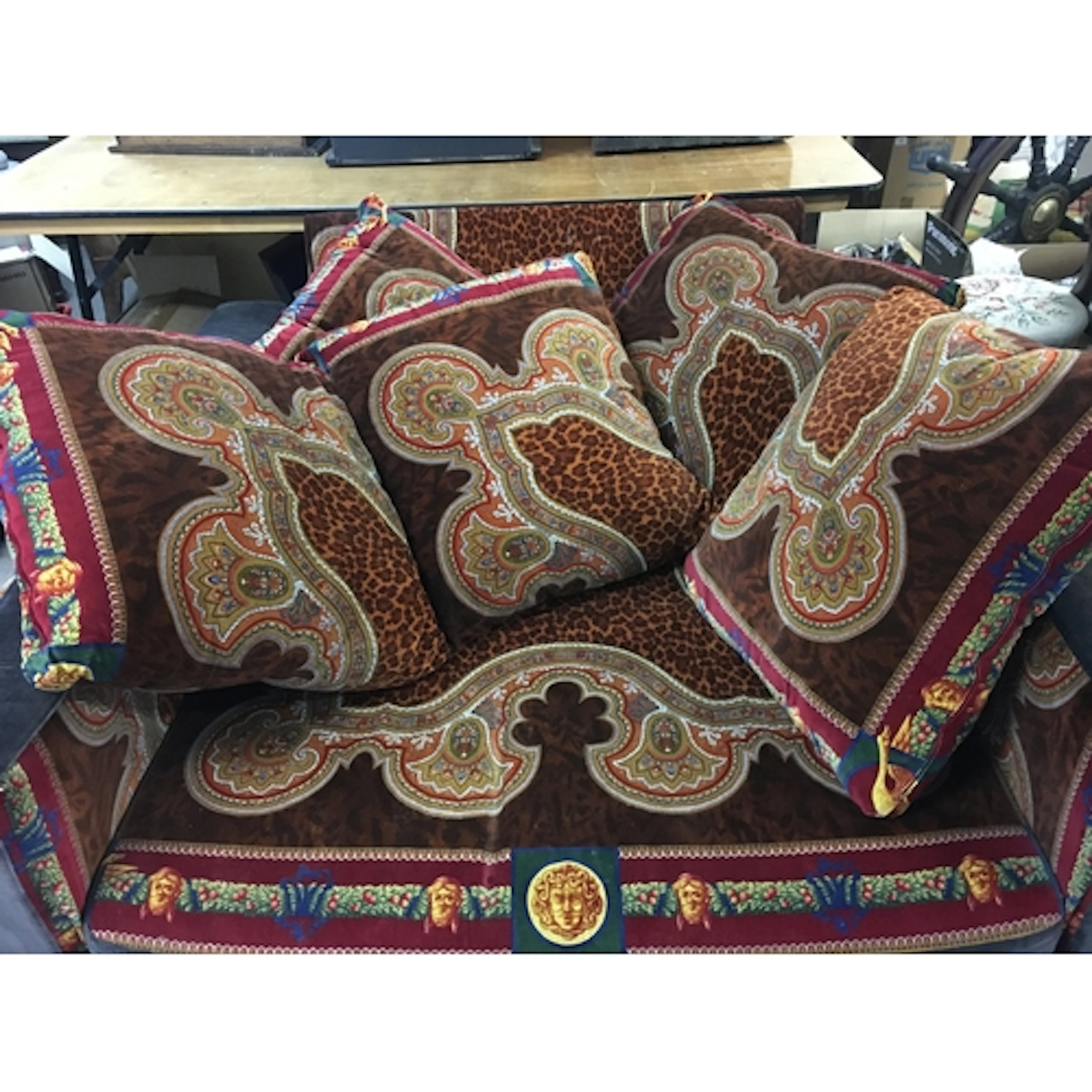 A three piece Versace suite including two sofas, a large cha...