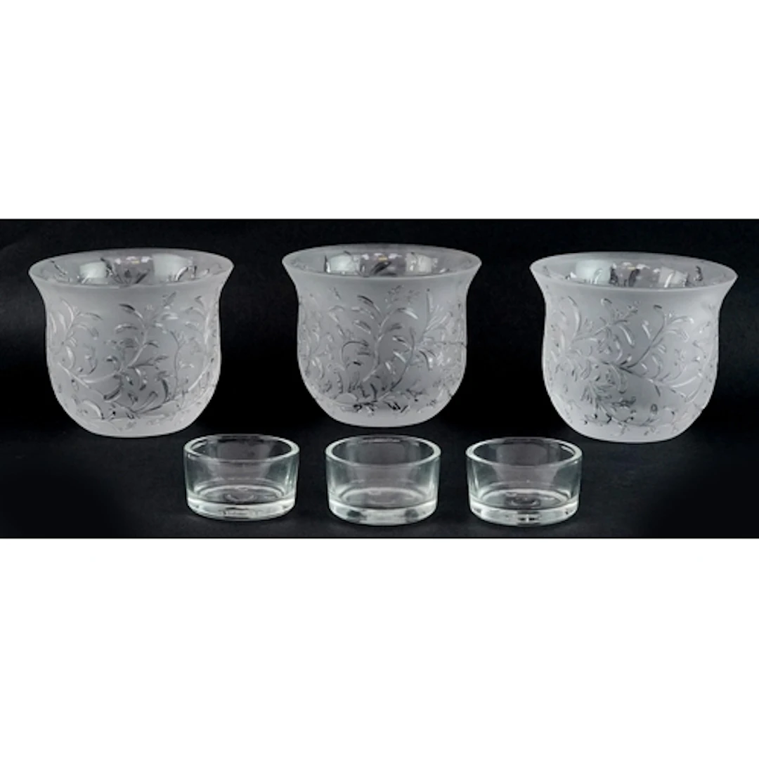 Three Lalique frosted glass tealight holders in the Rosemary...