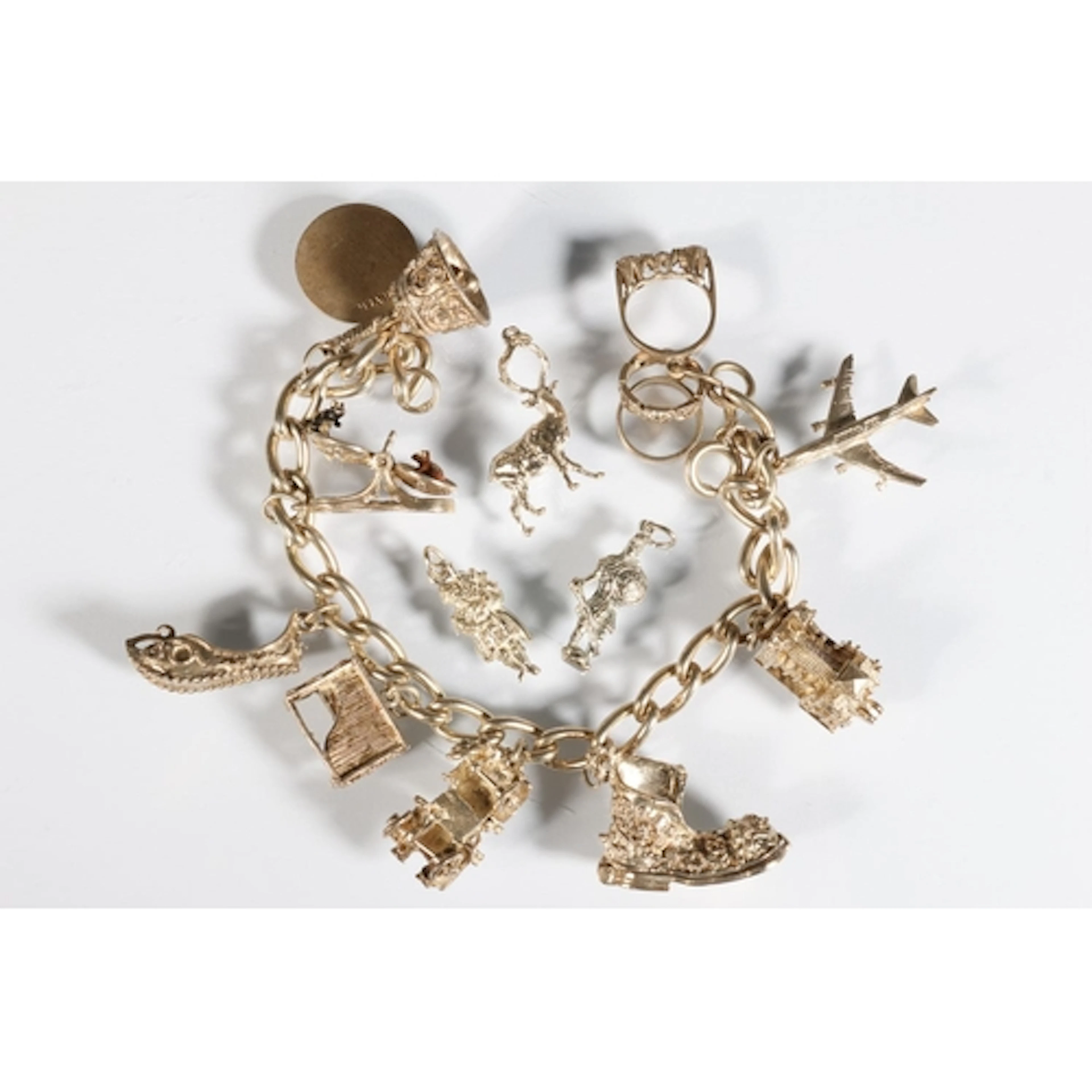 Silver charm bracelet of curb links with charms including pl...