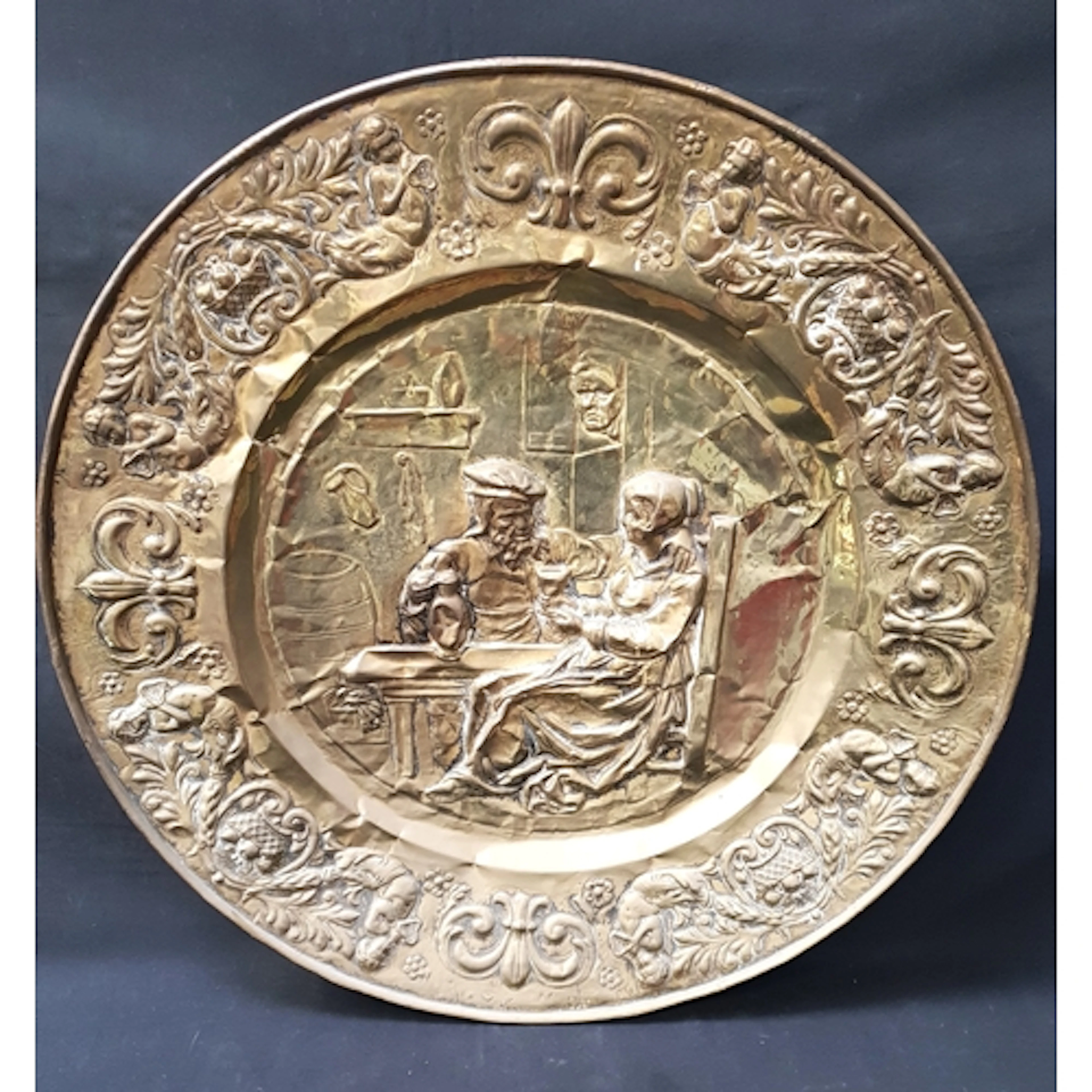 LARGE RELIEF DECORATED BRASS WALL CHARGER the circular charg...
