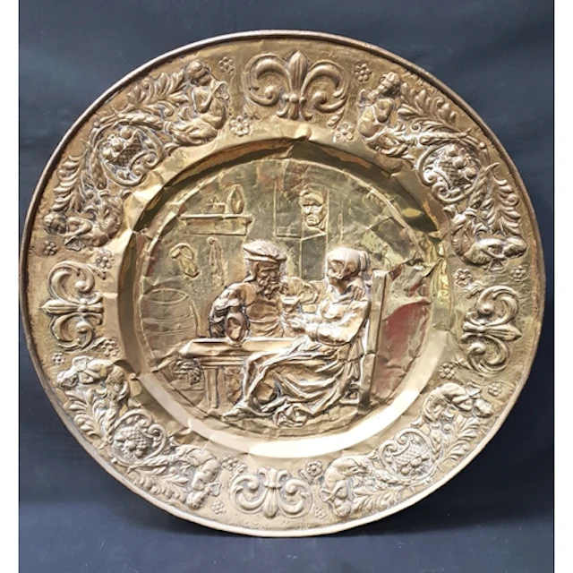LARGE RELIEF DECORATED BRASS WALL CHARGER the circular charg...