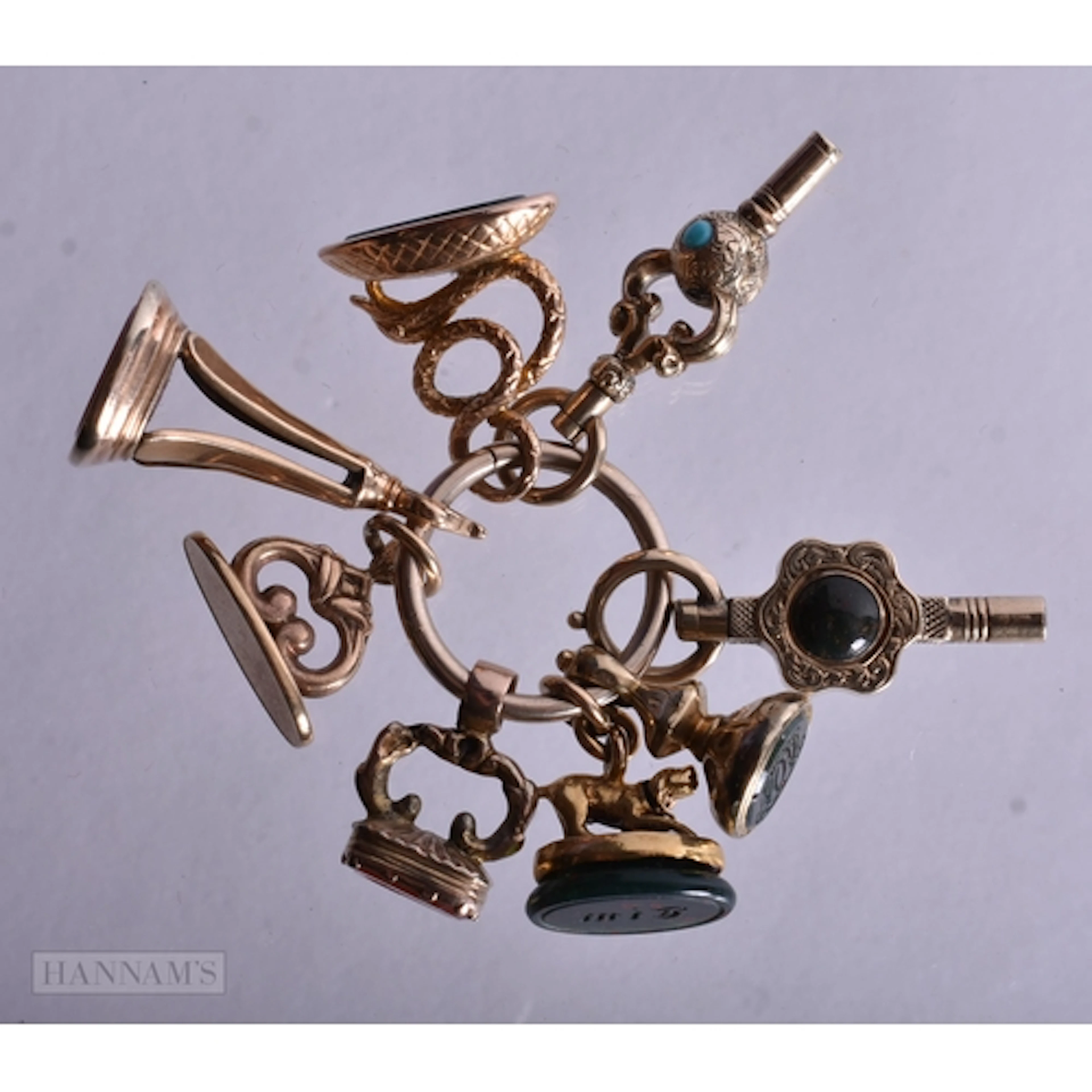 A 9CT GOLD RING with four attached 9ct gold charms and four ...