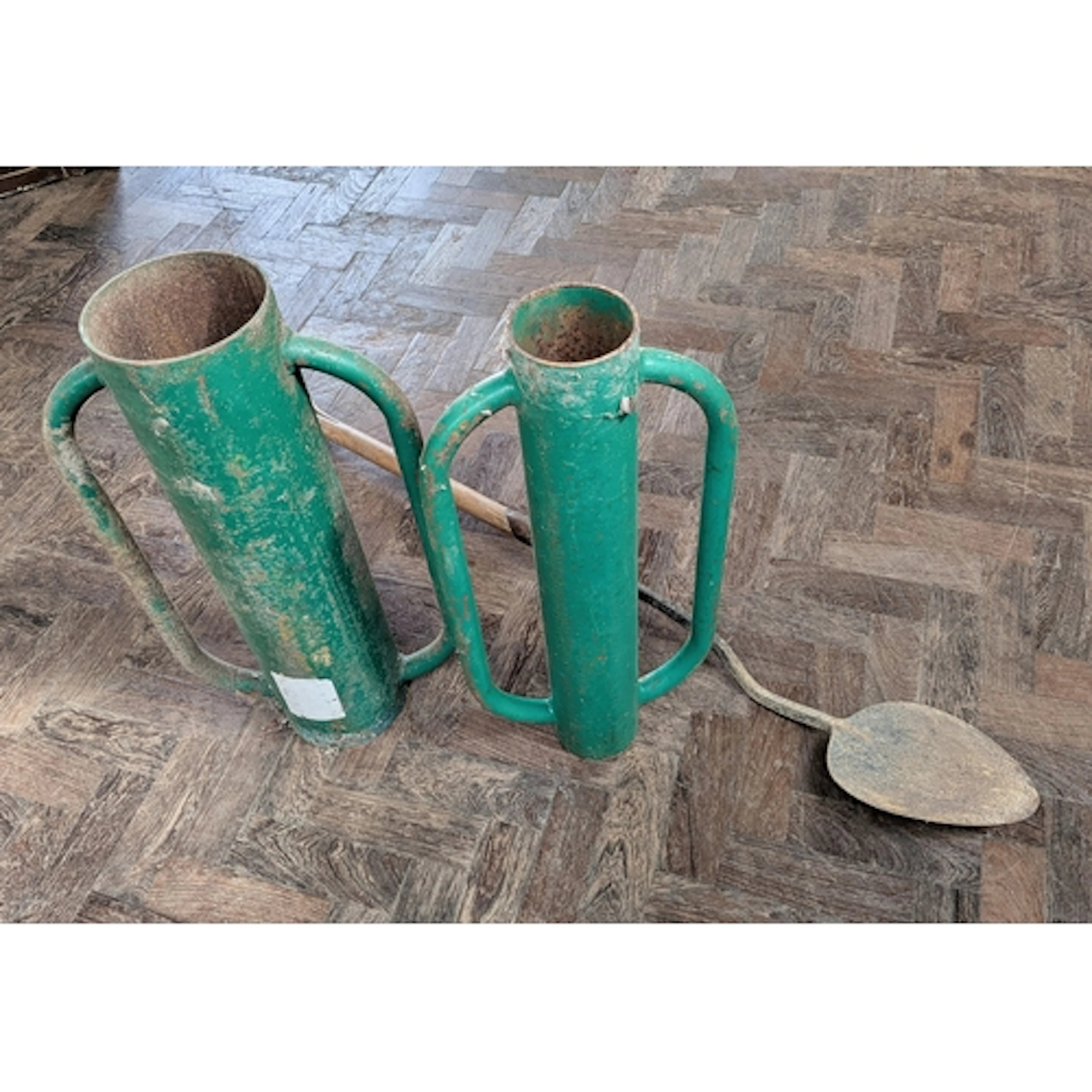 Two green heavy duty fence post drivers together with a vint...