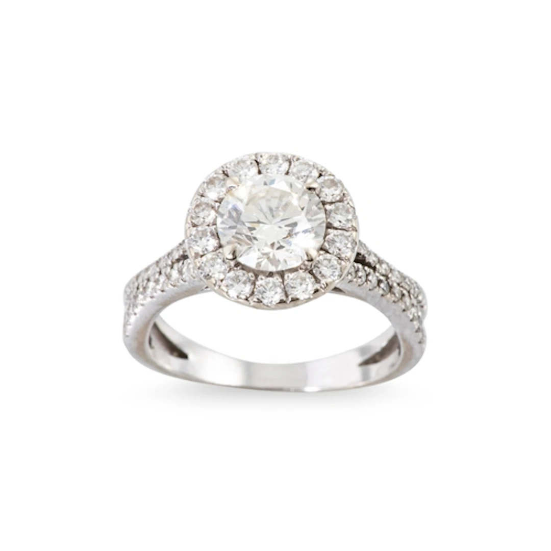 A DIAMOND SOLITAIRE RING, the brilliant cut diamond to halo ...