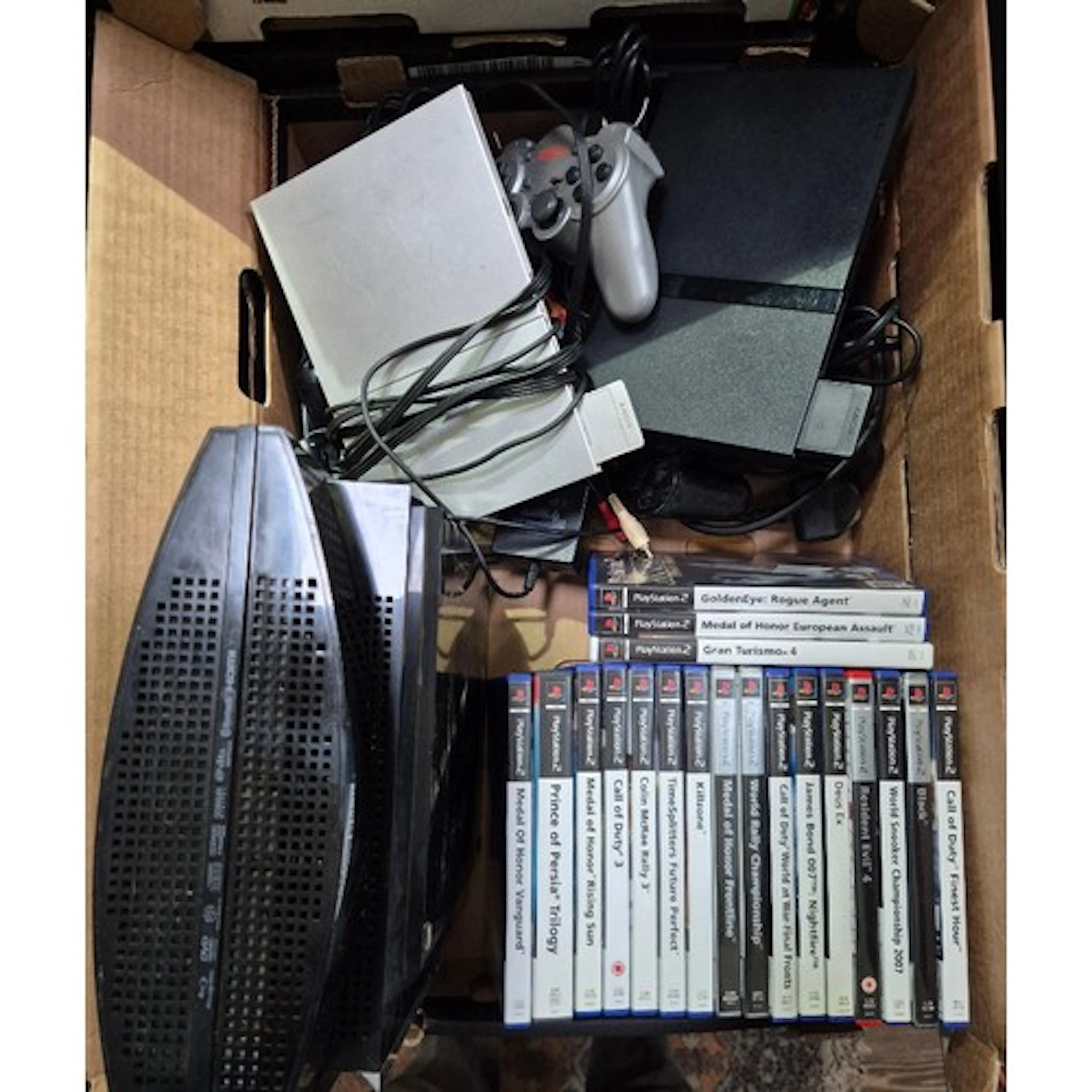 A box containing 2 x PS2, a playstation 3, PS2 games & contr...