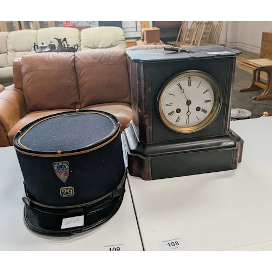A black striking marble mantle clock together with a black k...
