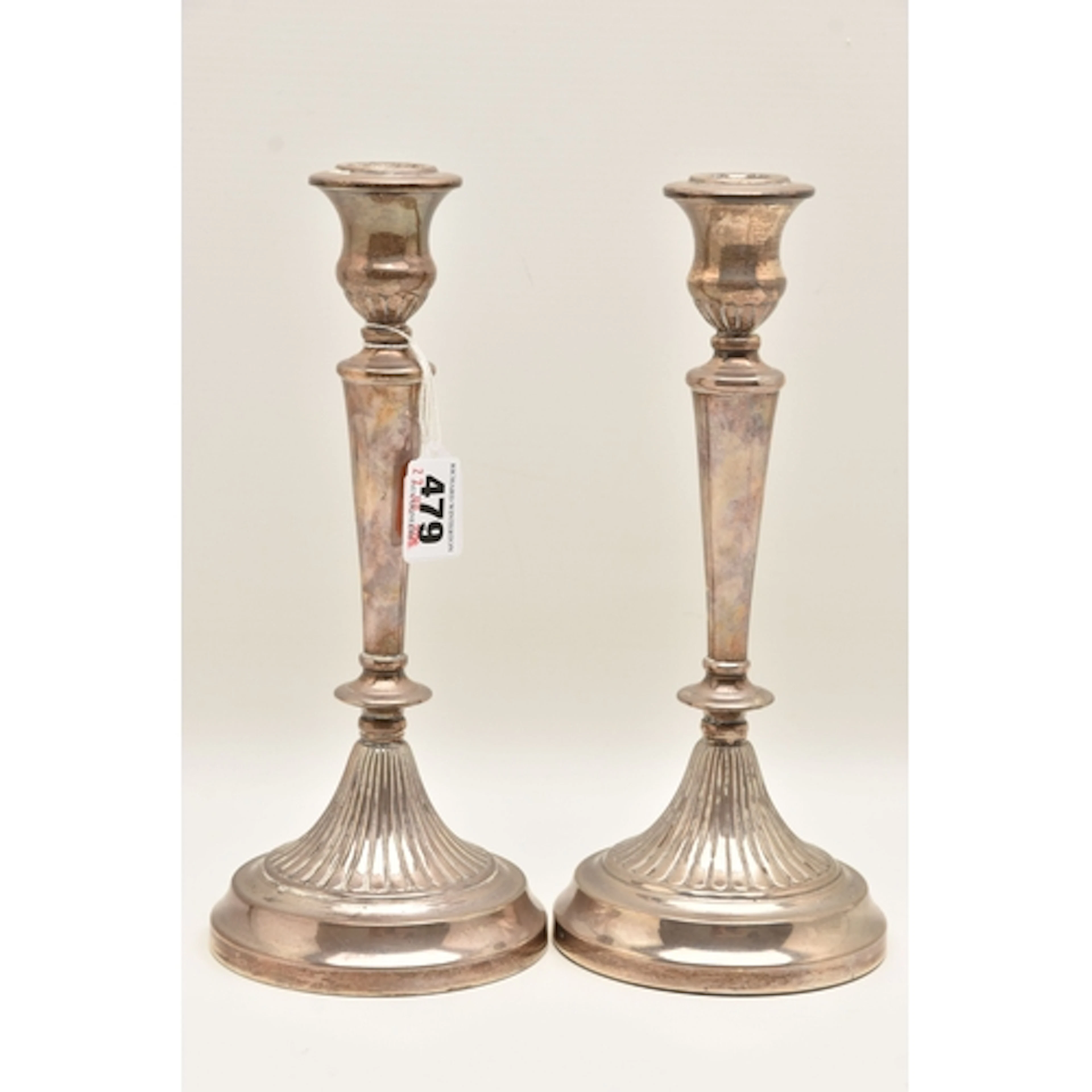 A PAIR OF WHITE METAL WEIGHTED BASE CANDLE STICK HOLDERS, ap...