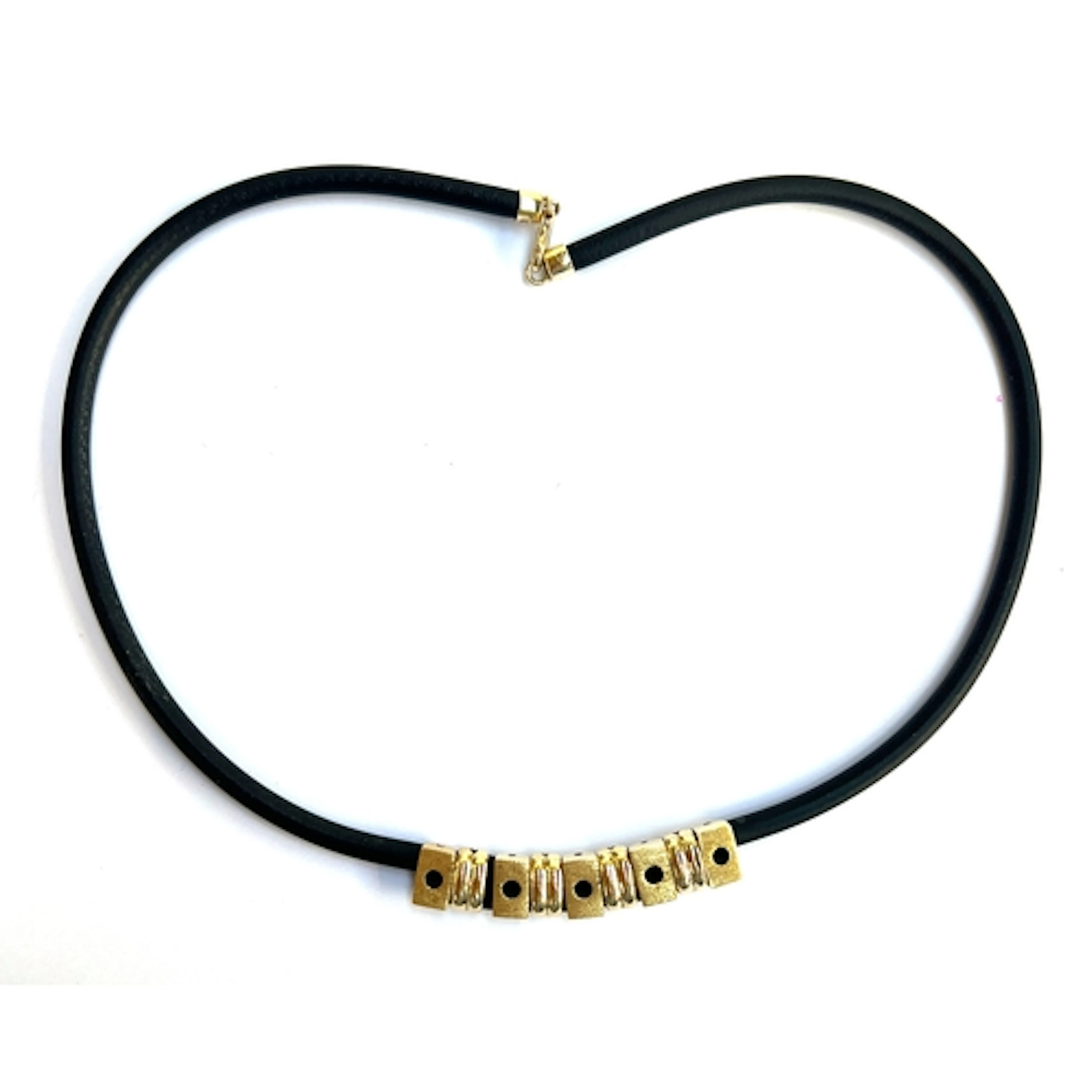 A rubber cord necklace mounted with 14ct gold beads, each st...