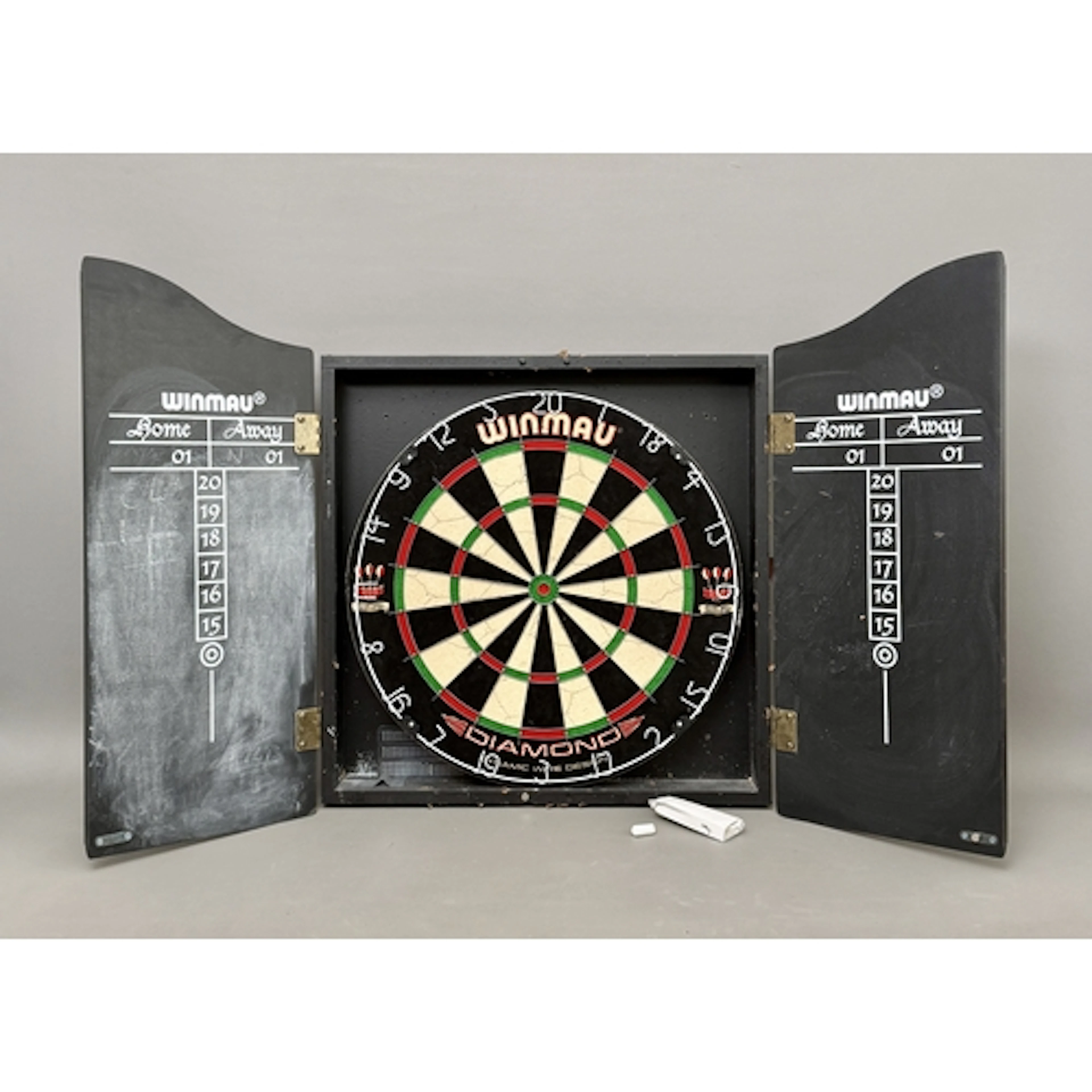 A Winmau Diamond bristle dartboard - in a Winmau faux-wood g...