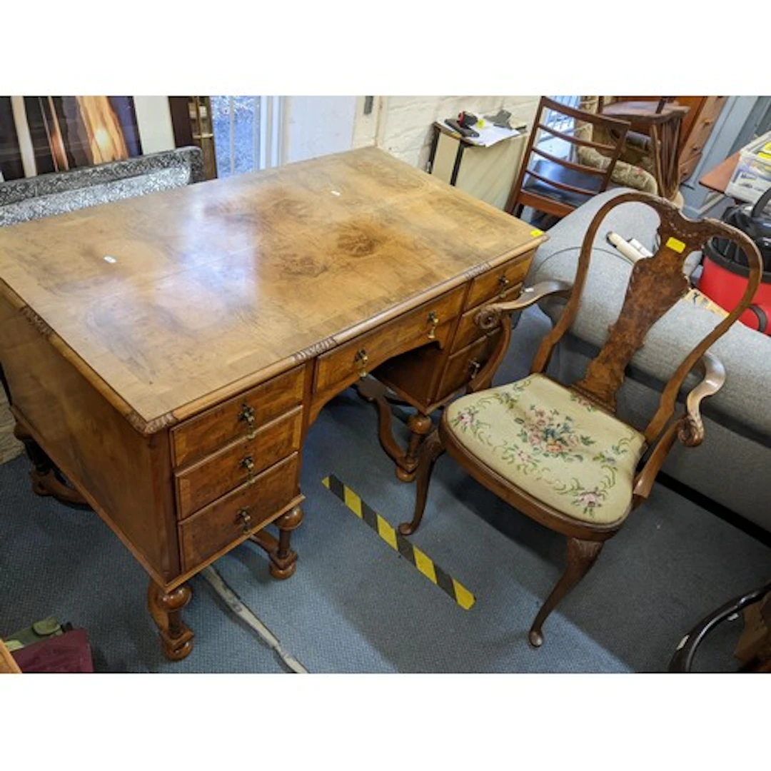 An early/mid 20th century walnut desk having seven drawers w...
