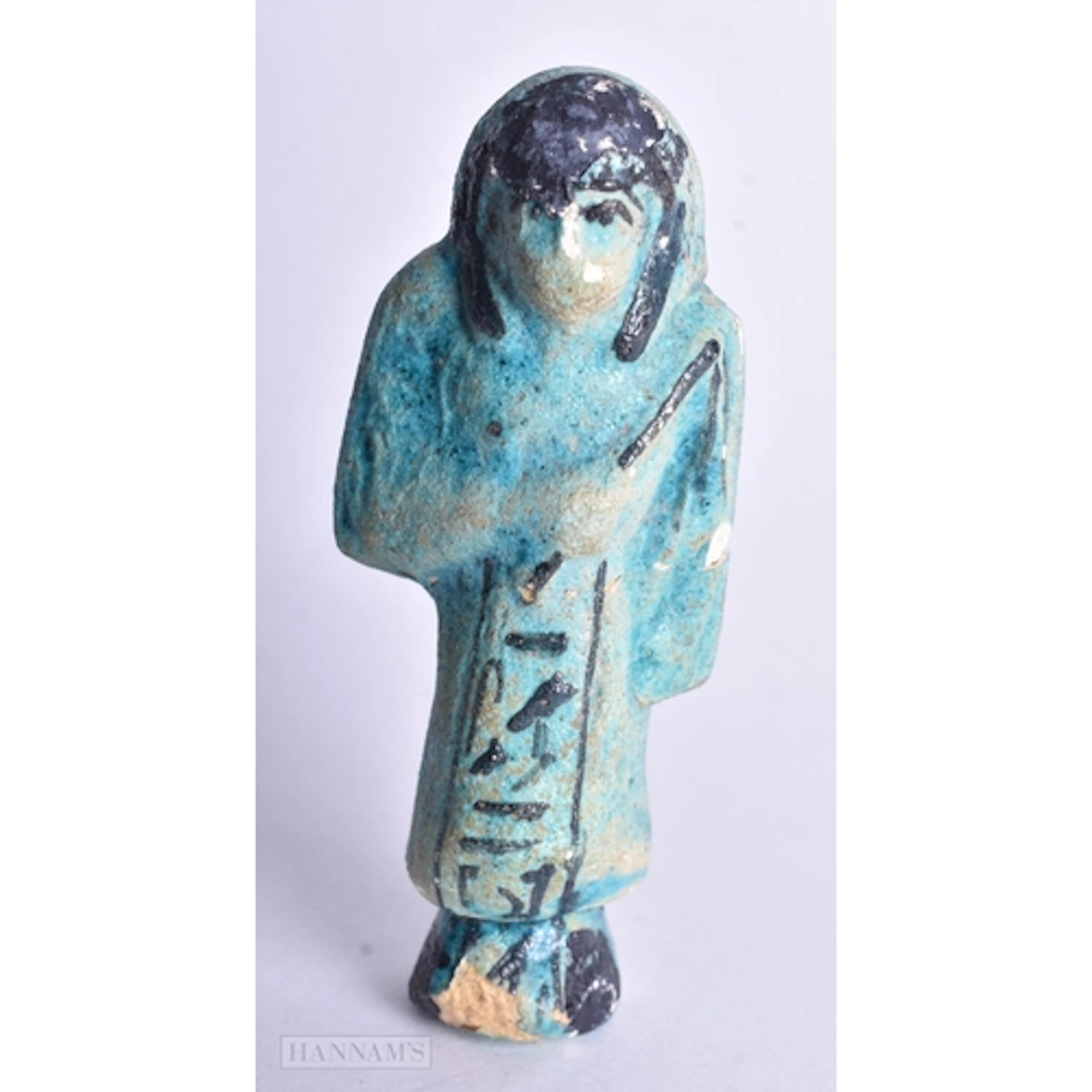 AN EGYPTIAN FAIENCE USHABTI. 8.5 cm high.