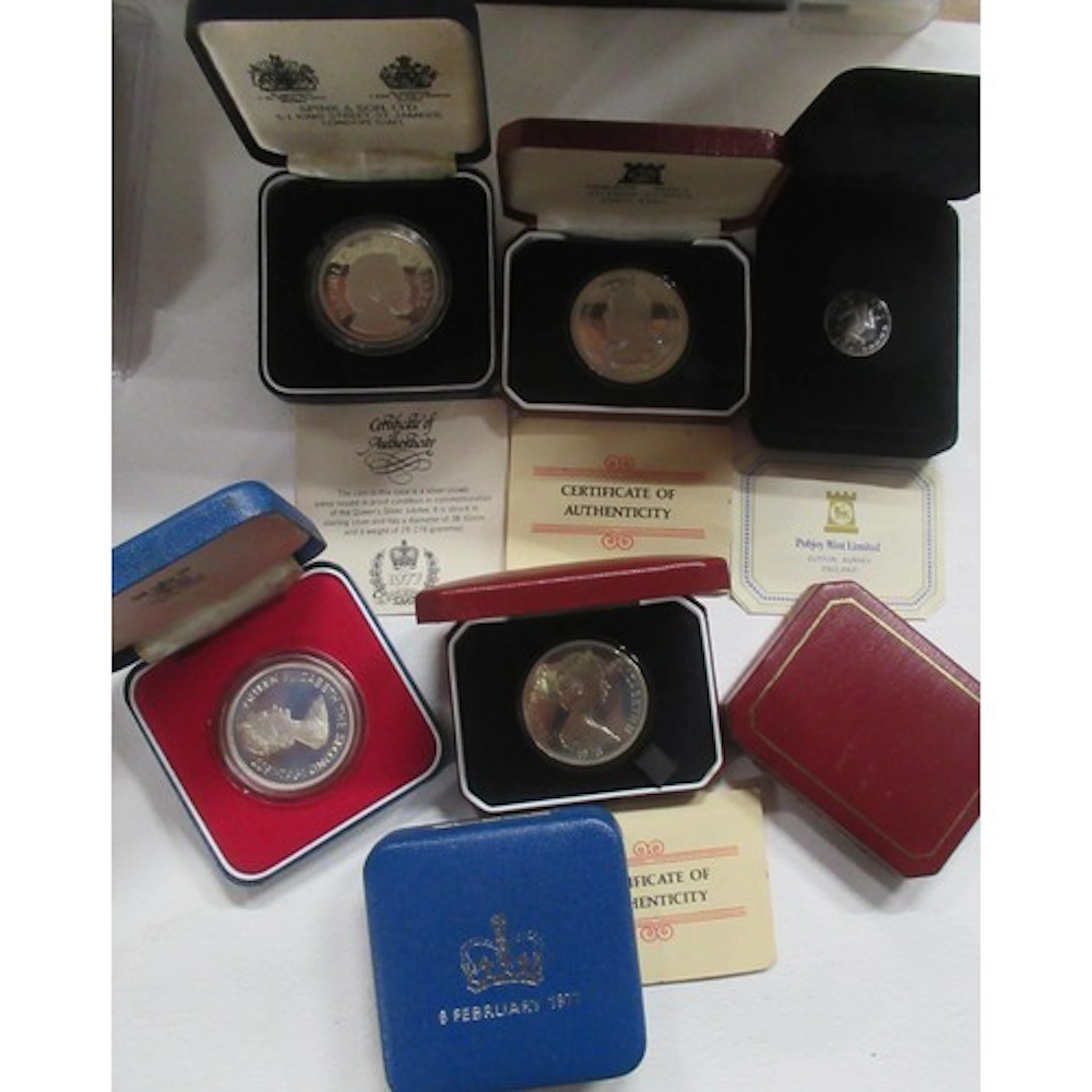 A collection of seven cased coins, to include a hallmarked s...
