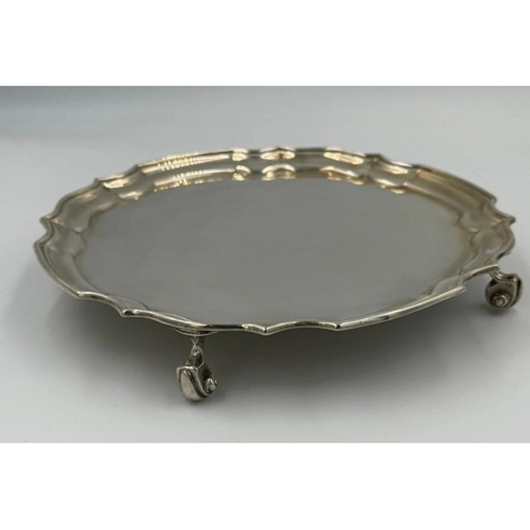 A scalloped edged silver tray on four feet, approximate weig...