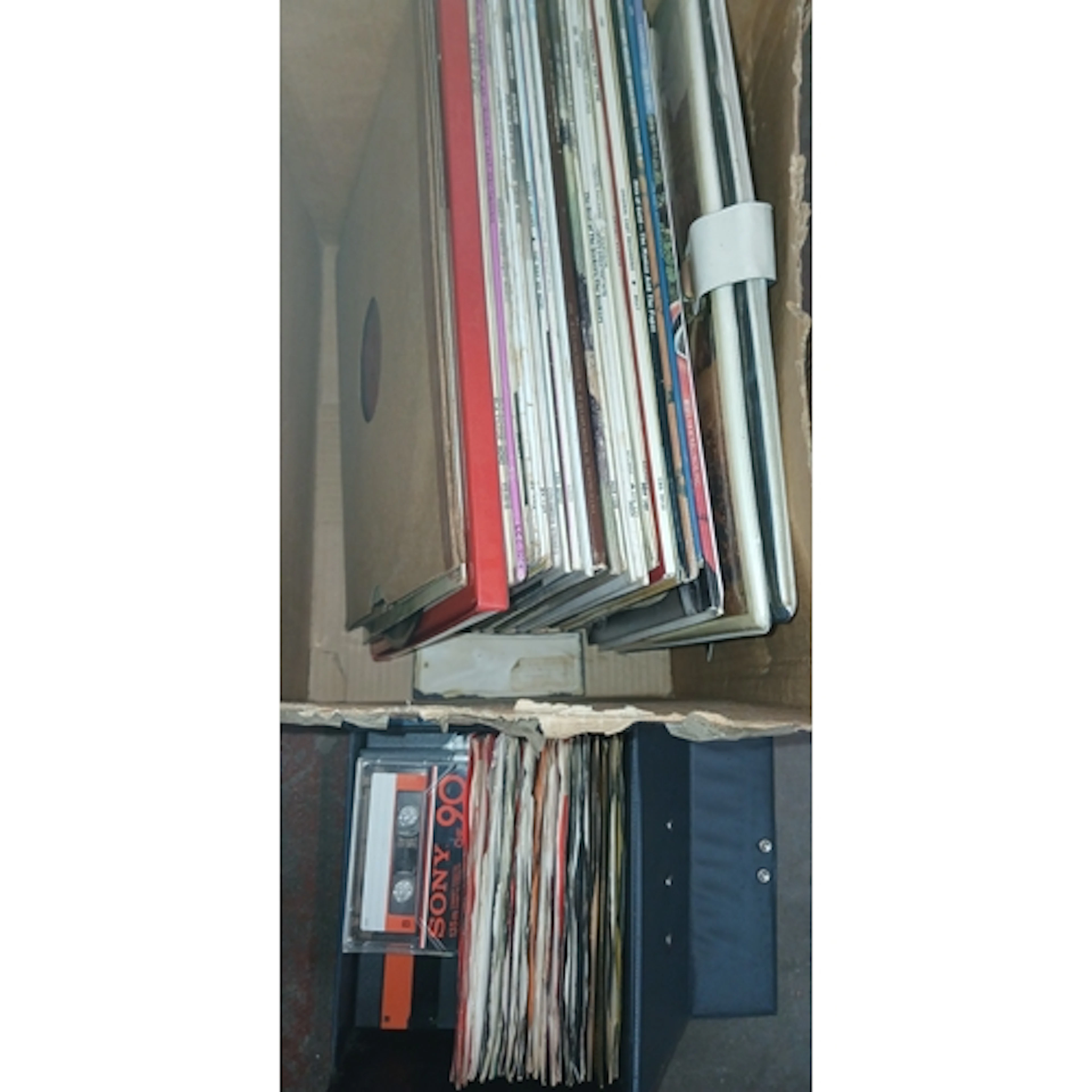 A box of assorted LPs and a case of singles.
