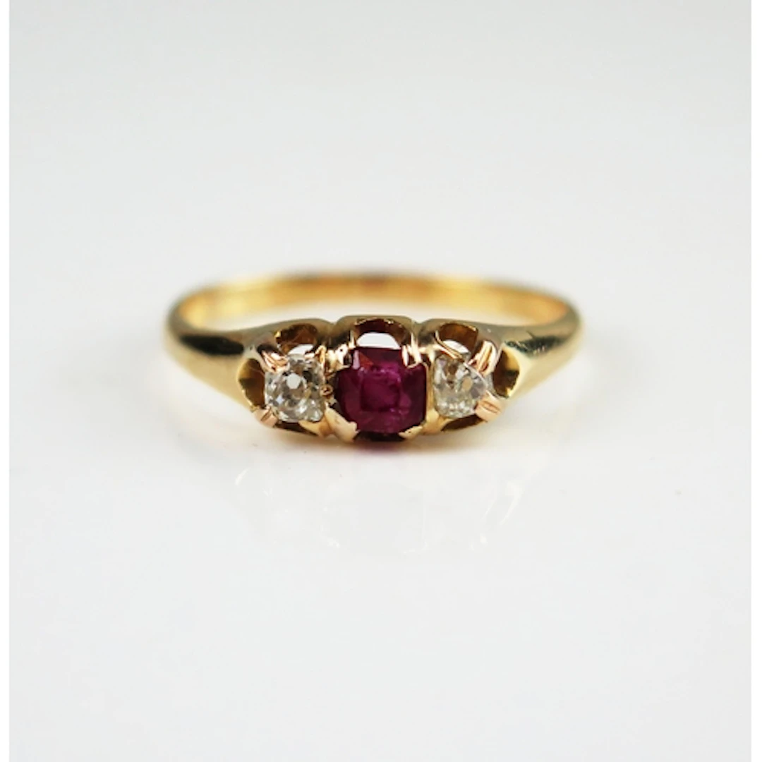 A ruby and old cut diamond three stone ring in a high carat ...