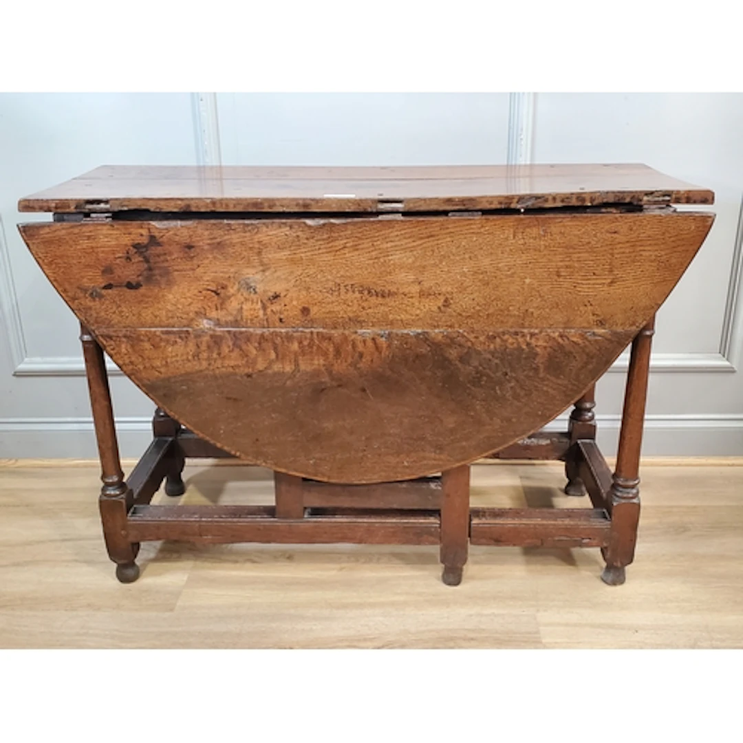 An antique oak Gateleg Table fitted end drawer raised on tur...