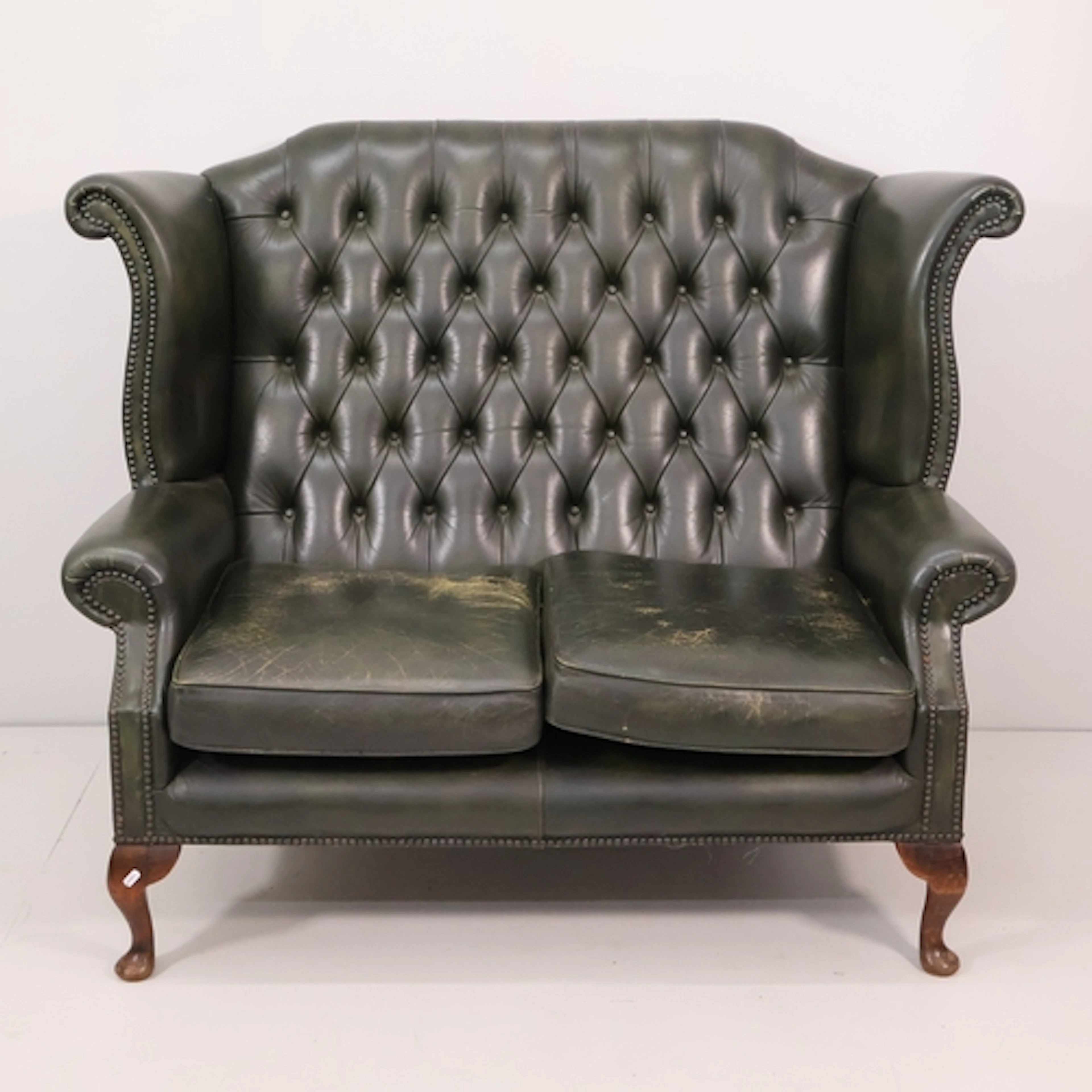A green button back leather upholstered 2-seater Chesterfiel...