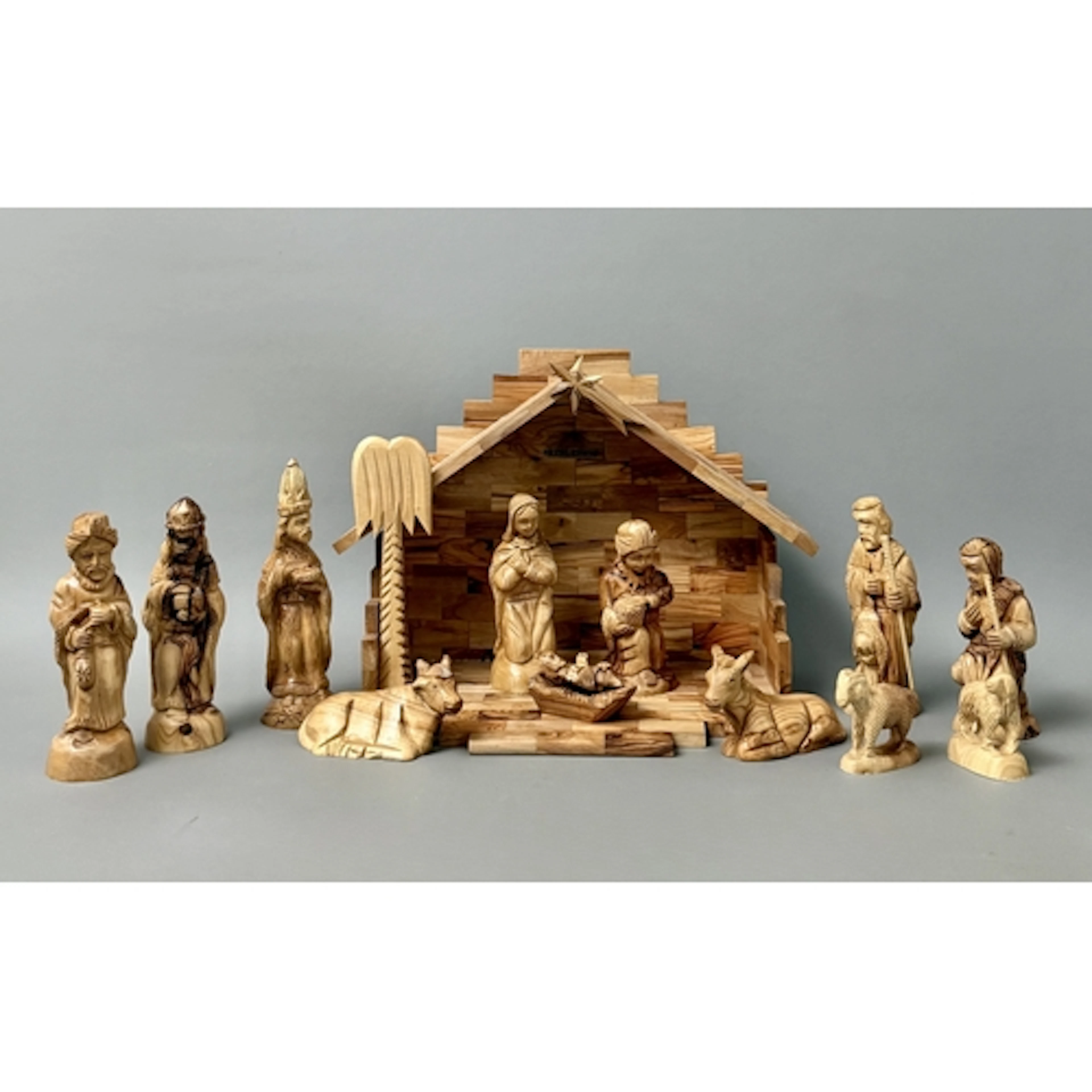 A contemporary fourteen piece nativity set - carved from oli...