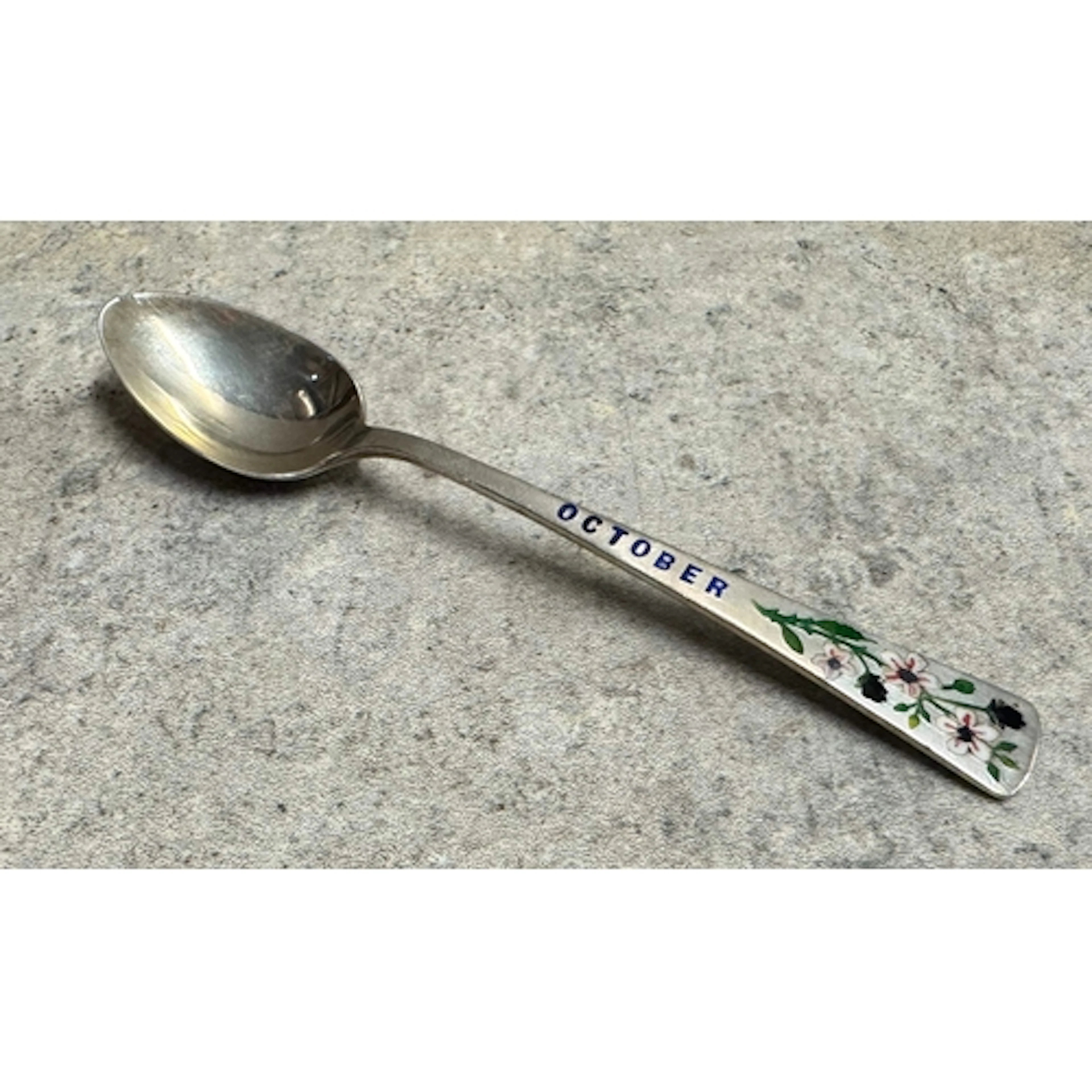 A silver and enamelled spoon with flower decoration. Birming...