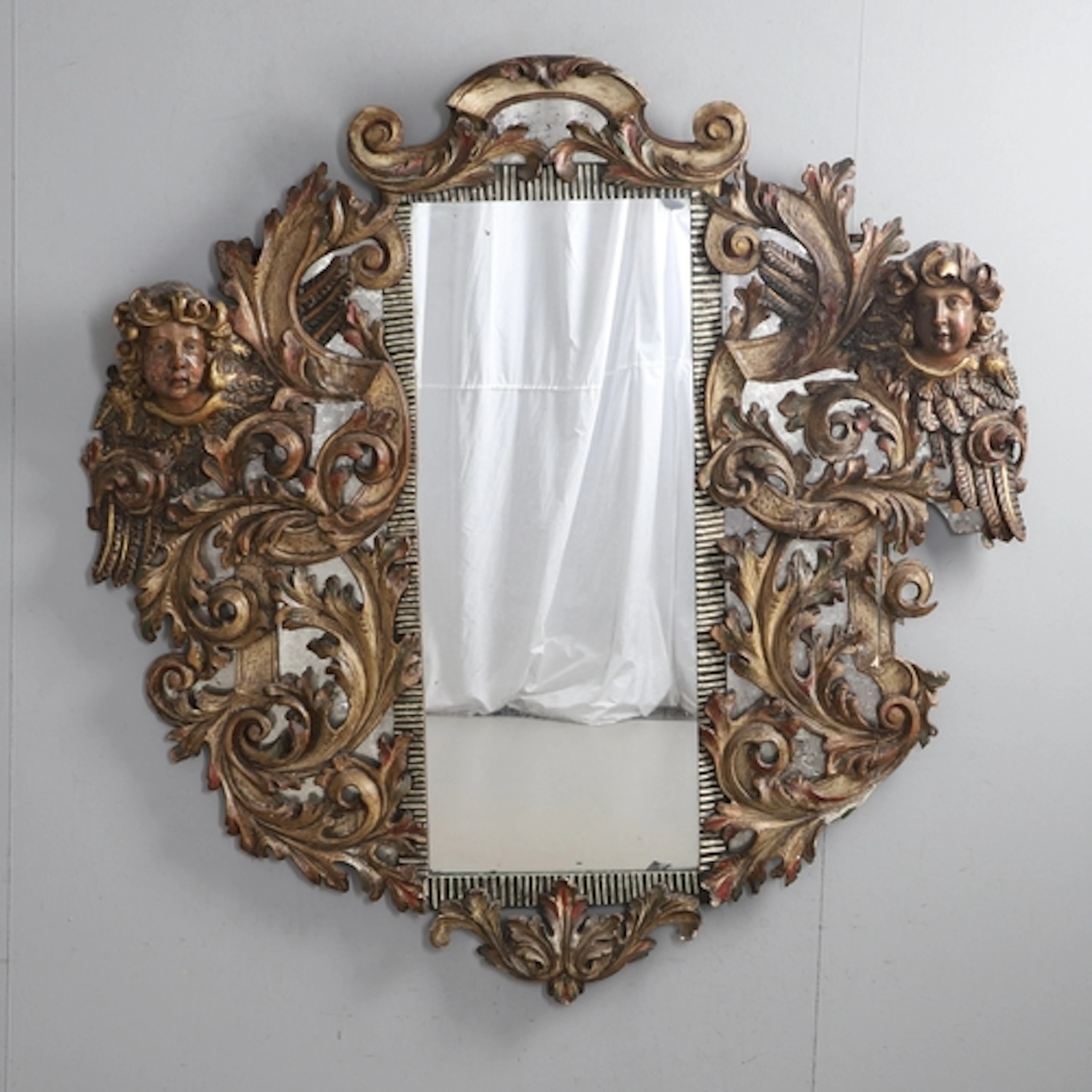 A 19TH CENTURY ITALIAN CARVED AND PAINTED WALL MIRROR. the o...