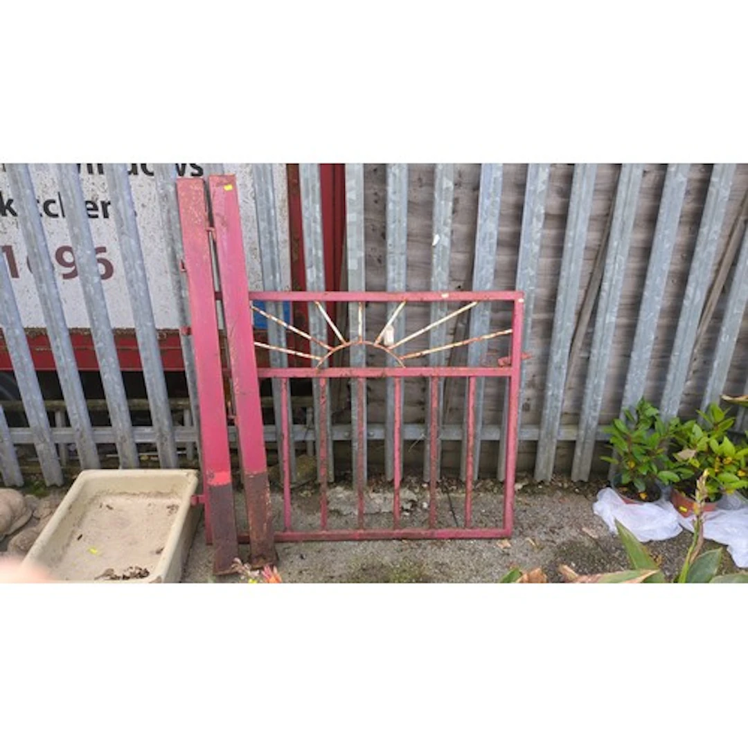 Painted iron garden gate with a sunburst upper register and ...