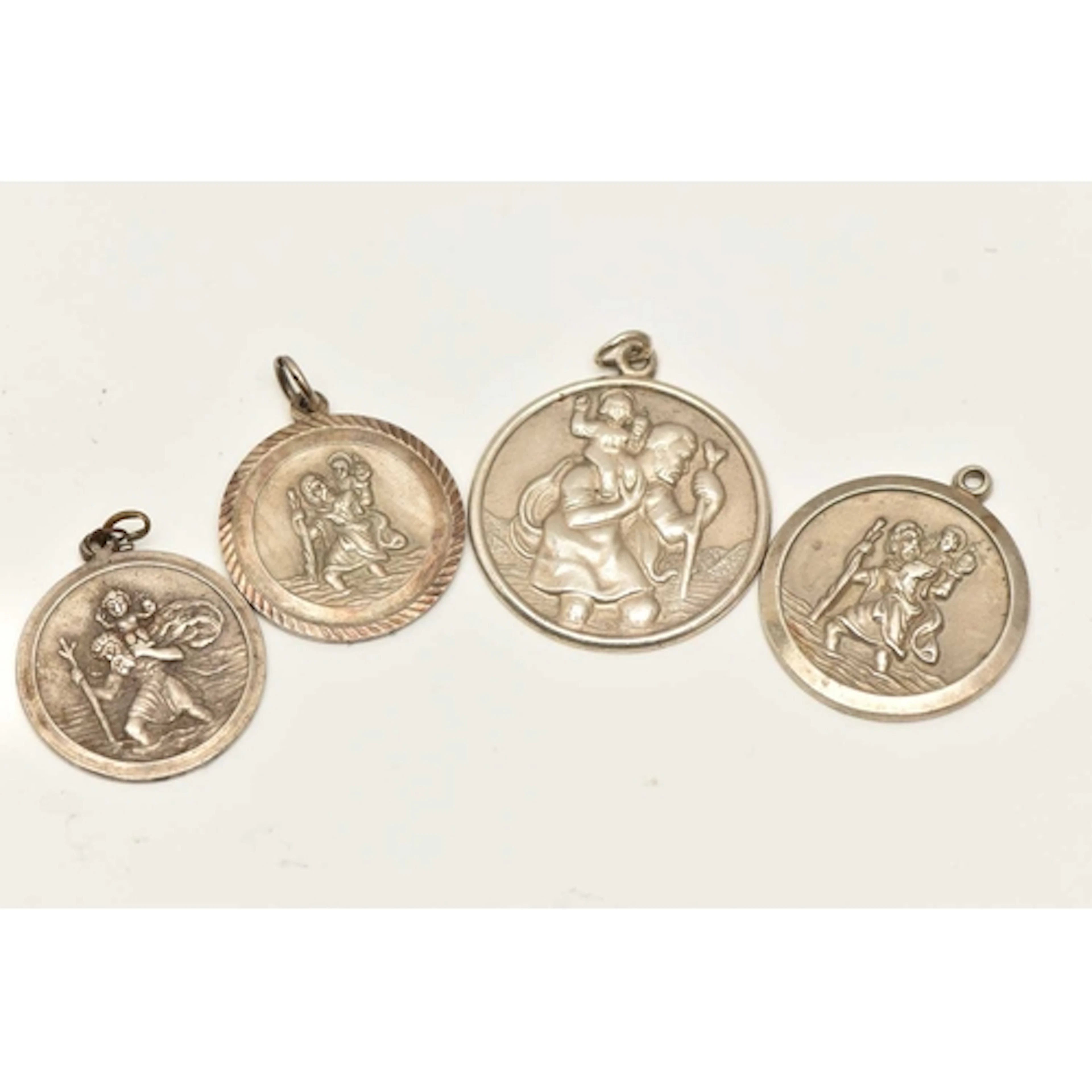 FOUR SILVER/WHITE METAL ST.CHRISTOPHER PENDANTS, one hallmar...
