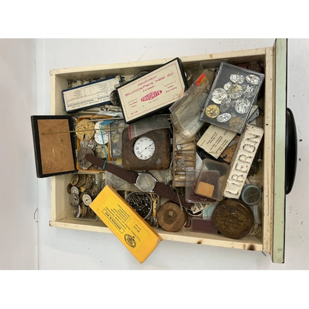 A tray containing assorted watch movers and parts