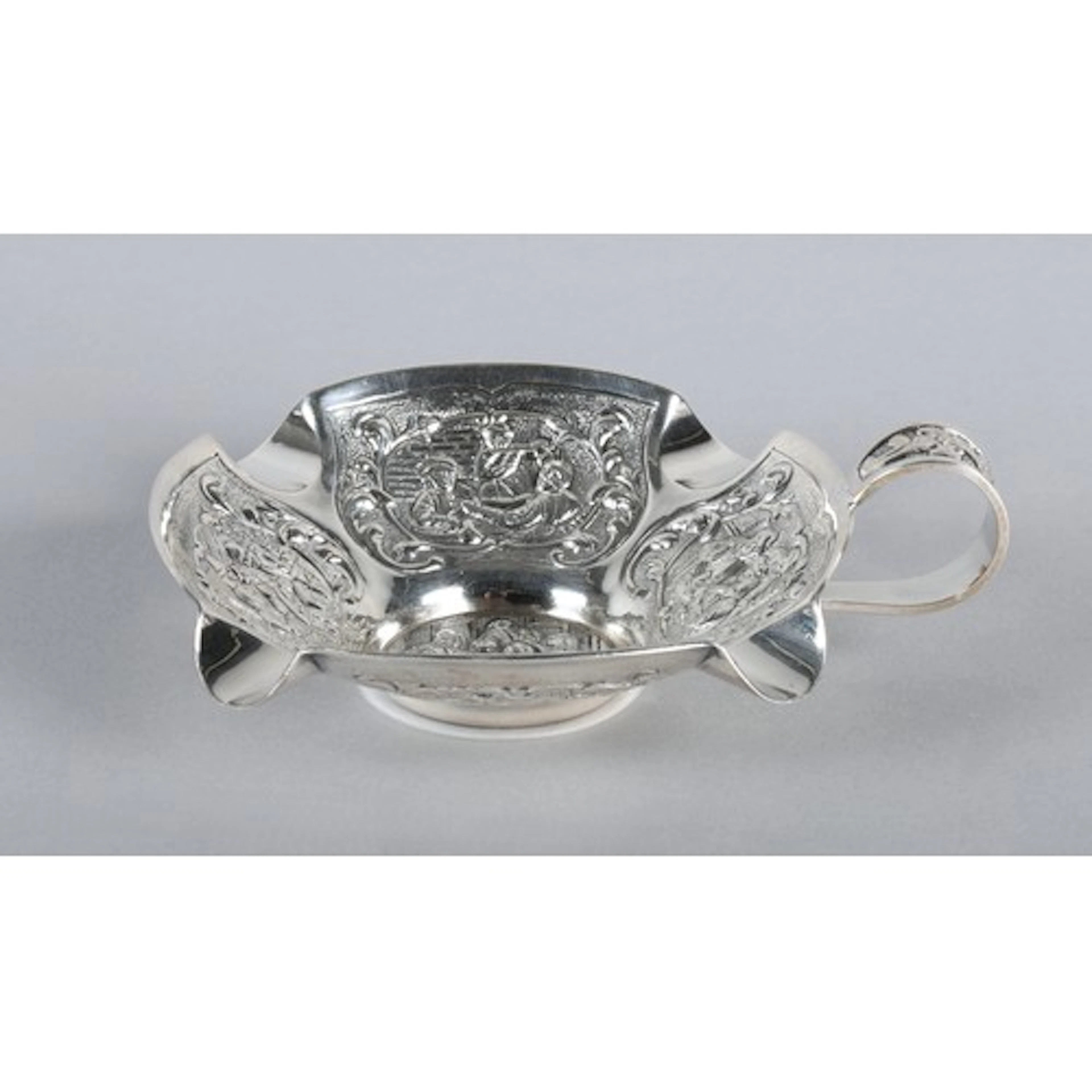 Silver coloured ashtray with scroll handle and four dimple a...
