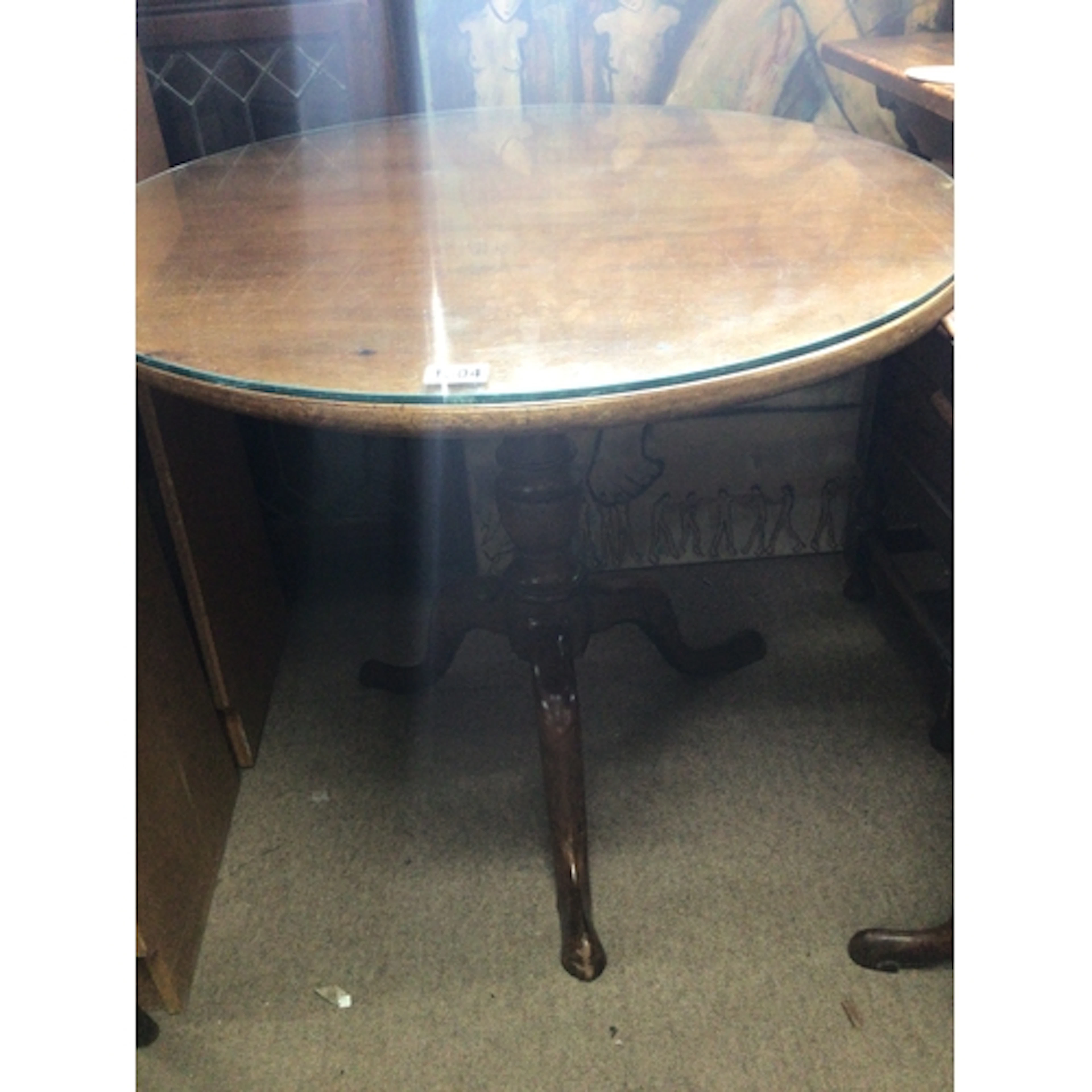 A late George III mahogany tip action table with a glass top...