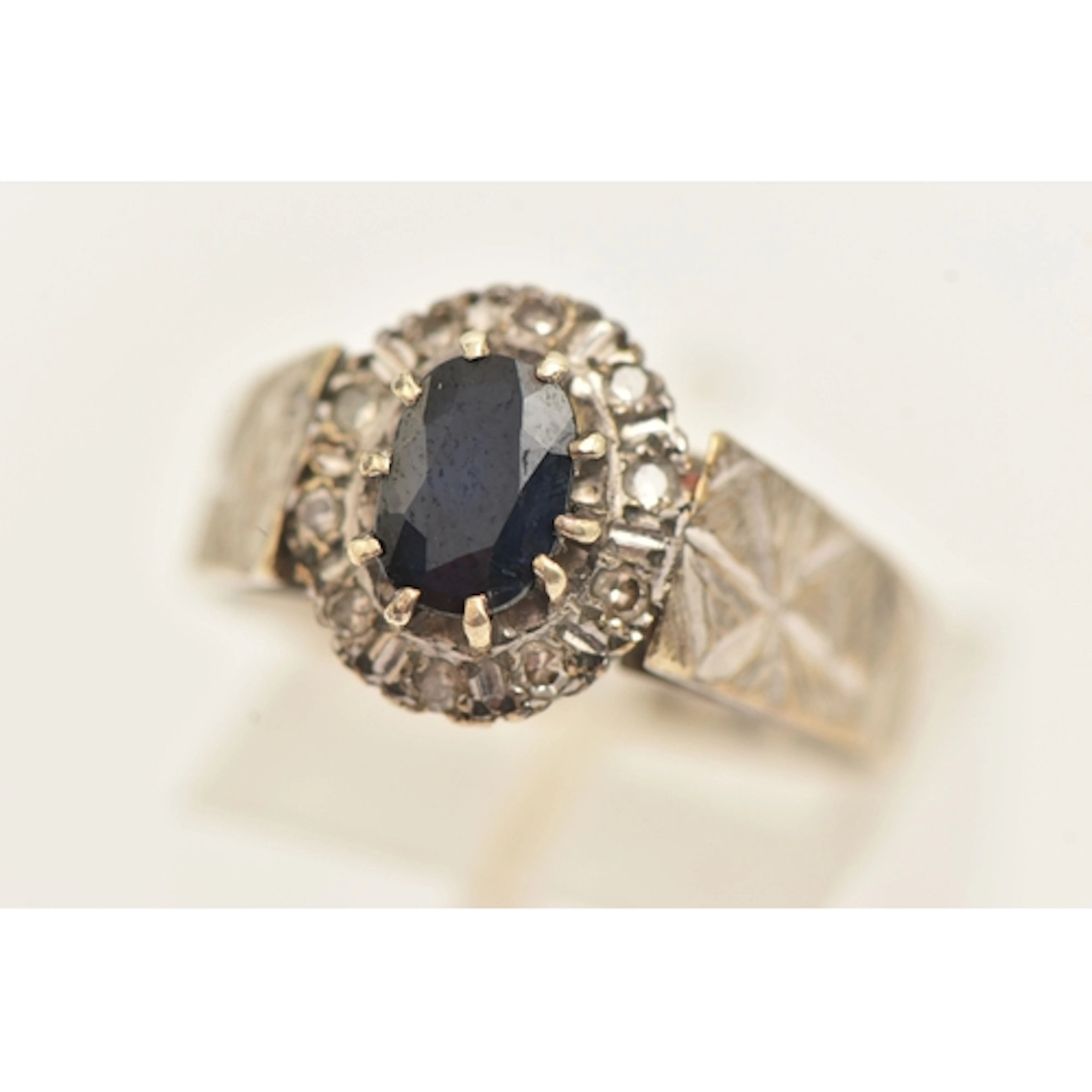 A 9CT GOLD SAPPHIRE AND DIAMOND CLUSTER RING, of an oval for...