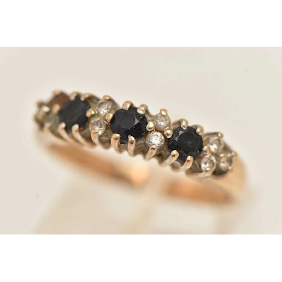 A 9CT YELLOW GOLD GEM SET RING, three dark blue sapphires an...