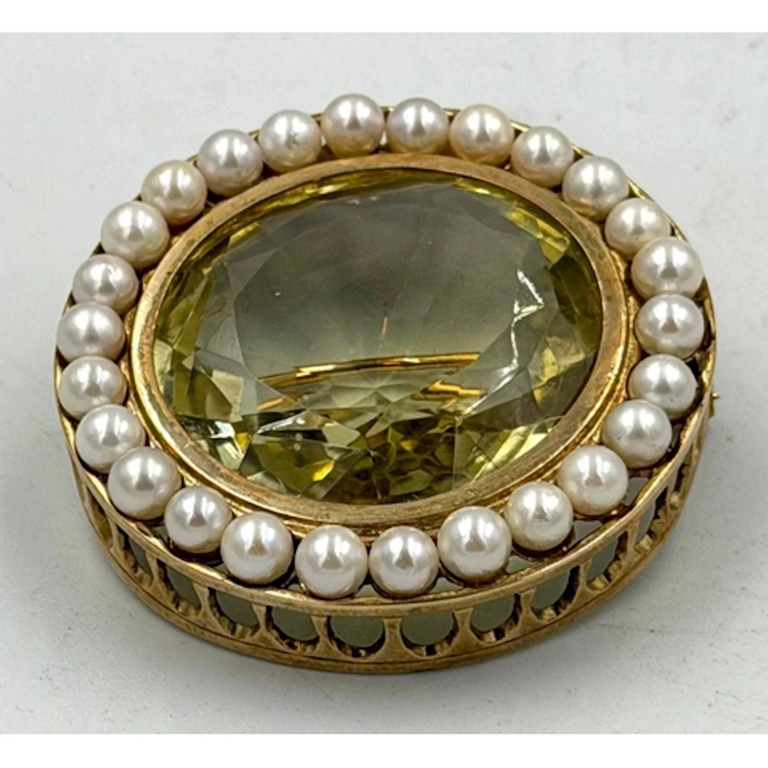 A circular pearl and citrine style gold tone brooch