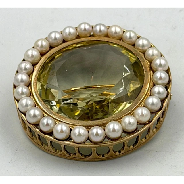 A circular pearl and citrine style gold tone brooch